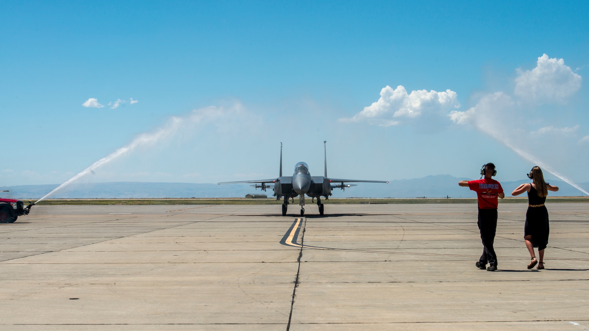 Col. Thomas Palmer, 366th Fighter Wing chief of staff, passes under a water salute, Aug. 2, 2019 at Mountain Home Air Force Base, Idaho. Palmer flew his last flight within an F-15E before retiring from the U.S. Air Force. (U.S. Air Force photo by Airman 1st Class Eric Brown)