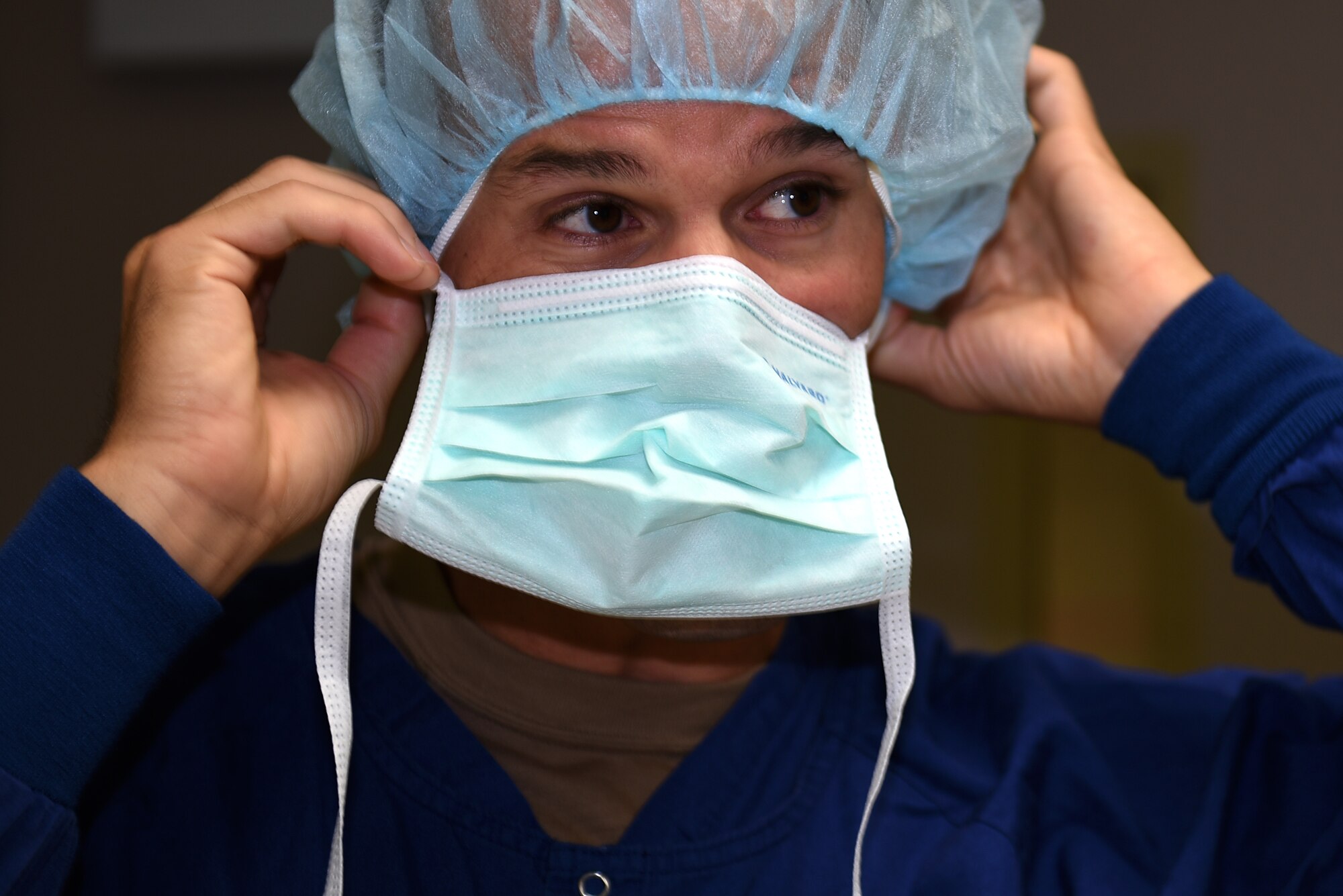 U.S. Air Force Col. Zachery Jiron, 60th Air Mobility Wing vice commander, dons a surgical mask to enter a sterile room in the operating facilities during a Leadership Rounds Aug. 8, 2019, at David Grant USAF Medical Center Travis Air Force Base, California. As part of the Leadership Rounds program, Jiron participated in a simulated surgery to get a firsthand experience of all the precautions medical staff take before every surgery. (U.S. Air Force photo by Airman 1st Class Cameron Otte)