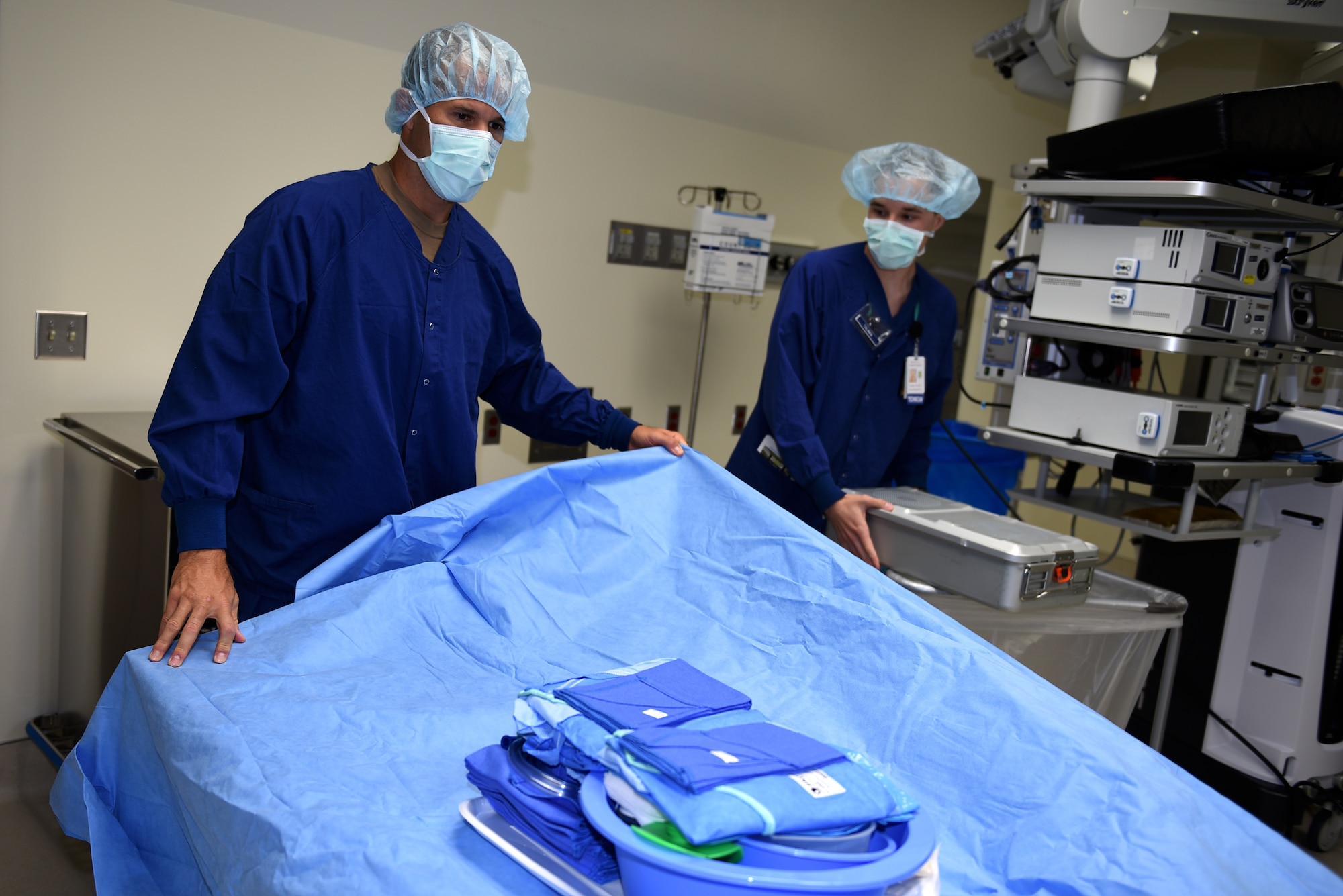 U.S. Air Force Airman 1st Class Hunter Talikka, 60th Surgical Operations Squadron surgical technician, instructs Col. Zachery Jiron, 60th Air Mobility Wing vice commander, on how to set a table for surgery Aug. 8, 2019, at David Grant USAF Medical Center Travis Air Force Base, California. As part of the Leadership Rounds program, Jiron participated in a simulated surgery to get a firsthand experience of all the precautions medical staff take before every surgery. (U.S. Air Force photo by Airman 1st Class Cameron Otte)