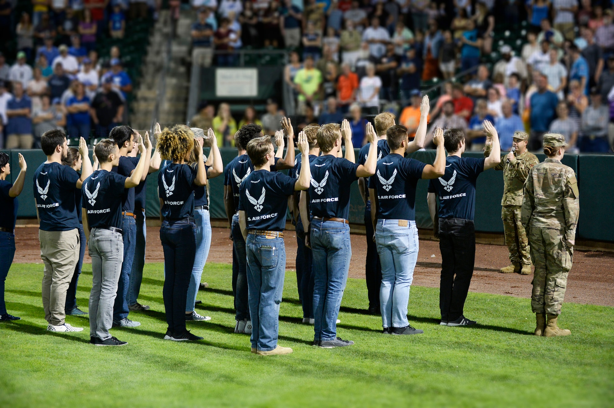 Lt. Col. Jason Haney, 368th Recruiting Squadron commander, gives the oath of enlistment to 22 Air Force recruits during the Aug. 9, 2019, Military Appreciation Night with the Ogden Raptors and Idaho Falls Chuckars at Lindquist Field in Ogden, Utah. Each year, the Raptors and Top of Utah Military Affairs Committee offer tickets to Hill Air Force Base personnel and their families. (U.S. Air Force photo by David Perry)