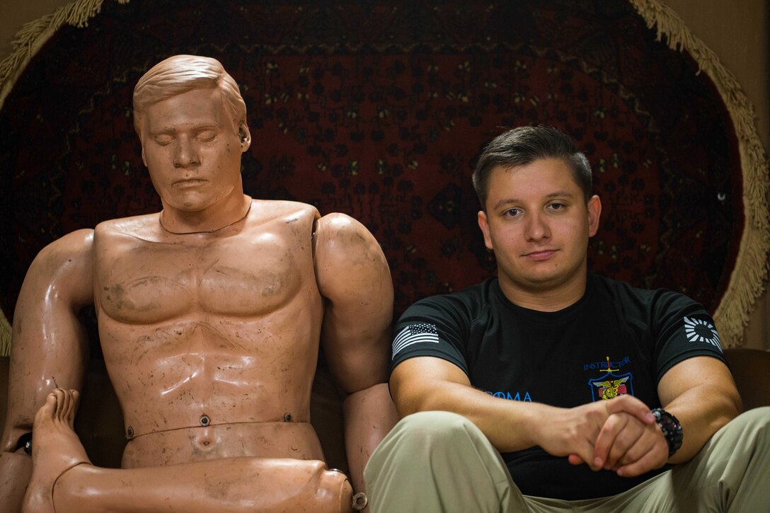 U.S. Navy Hospitalman Phillip Decoma rests next to a mannequin after the index of training for a mass casualty simulation at the Tactical Medical Simulation Center on Camp Hansen, Okinawa, Japan, August 1, 2019. The Tactical Combat Casualty Care course teaches first responders to treat casualties in the proper order, treating the most critical situations first to reduce deaths at the point of injury.  Decoma, a native of Belleville, New Jersey, is a TCCC course instructor with 3rd Medical Battalion, 3rd Marine Logistics Group. (U.S. Marine Corps photo by Lance Cpl. Isaiah Campbell)