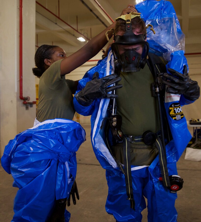 U.S. Marine Corps Lance Cpl. Mikelle A. Thompson, left, assists Cpl. Kendall Jones in putting on his Level-A Fully Encapsulated Chemical Protective Suit at Camp Kinser, Okinawa, Japan, August 1, 2019.  The suit provides the highest level of protection against unknown threats and protects wearers from substances known to damage lungs, skin and eyes. Thompson, a native of Philadelphia, Pennsylvania, and Jones, a native of Mason, Ohio, are both CBRN defense specialists with G-3, Enhanced CBRN Section, Combat Logistics Regiment 37, 3rd Marine Logistics Group. (U.S. Marine Corps photo by Lance Cpl. Carla E. O)