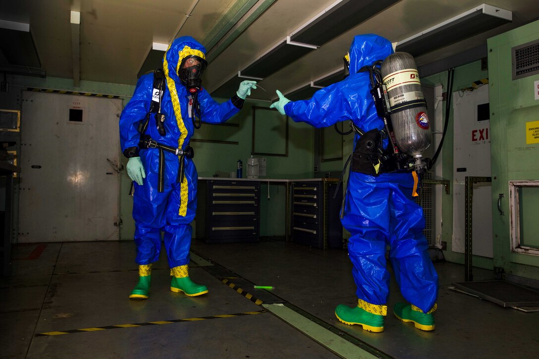 U.S. Marine Corps Lance Cpl. Phoenix Drohan, left, passes a ruler to Lance Cpl. Mikelle A. Thompson during a training exercise at Camp Kinser, Okinawa, Japan, August 1, 2019. Drohan and Thompson were responsible for documenting and collecting samples of unknown chemicals for testing during the training. Drohan, a native of San Diego, California, and Thompson, a native of Philadelphia, Pennsylvania, are both CBRN defense specialists with G-3, Enhanced CBRN Section, Combat Logistics Regiment 37, 3rd Marine Logistics Group. (U.S. Marine Corps photo by Lance Cpl. Carla E. O)
