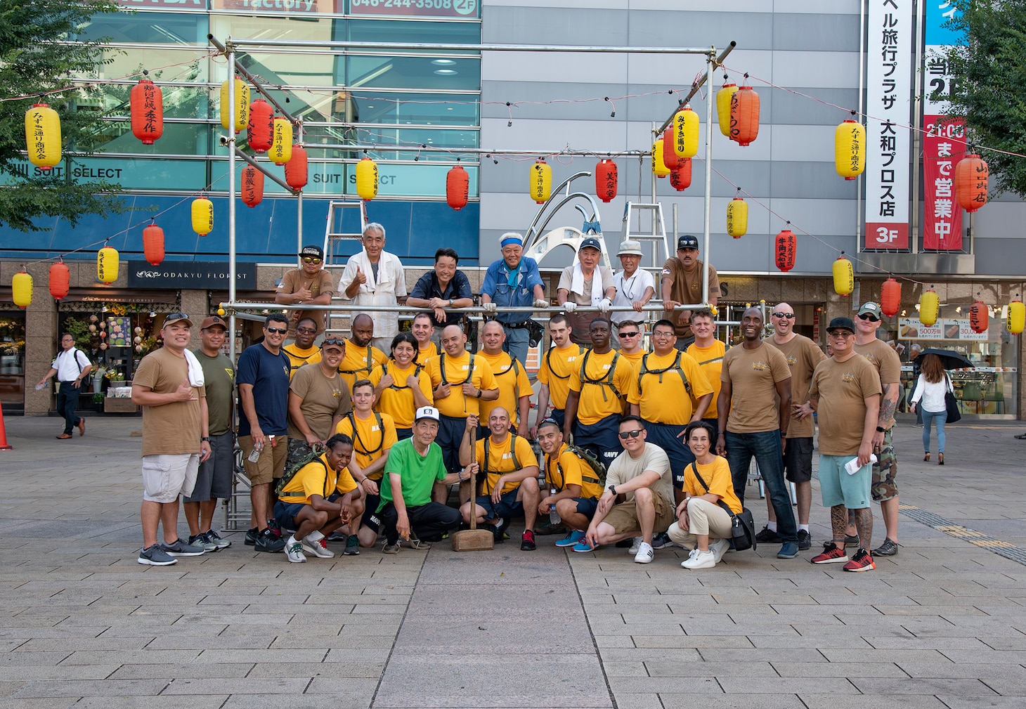 YAMATO, Japan (Aug. 09, 2019) Chief Petty Officers (CPO), CPO selectees and citizens from Yamato city pose for a group photo in front of the Yagura stage they assembled for the city's annual Yamato Furusato summer festival. The festival featured dance routines performed by members of the local community as well as Naval Air Facility Atsugi's Bon Odori dancers.