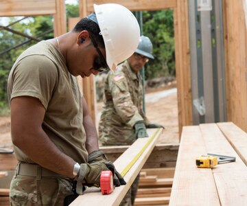 U.S. Army Pfc. Jesse Velez, a plumber assigned to the 1156th Engineer Company, 204th Engineer Battalion, New York Army National Guard, measures a board before cutting it during an Innovative Readiness Training (IRT) mission at Camp Paumalu, Haleiwa, Hawaii, July 31, 2019.Engineers from the Air Force, Air National Guard, and the Marine Corps have been working at the camp since May to help build a Science, Technology, Engineering, and Math (STEM) activity center.