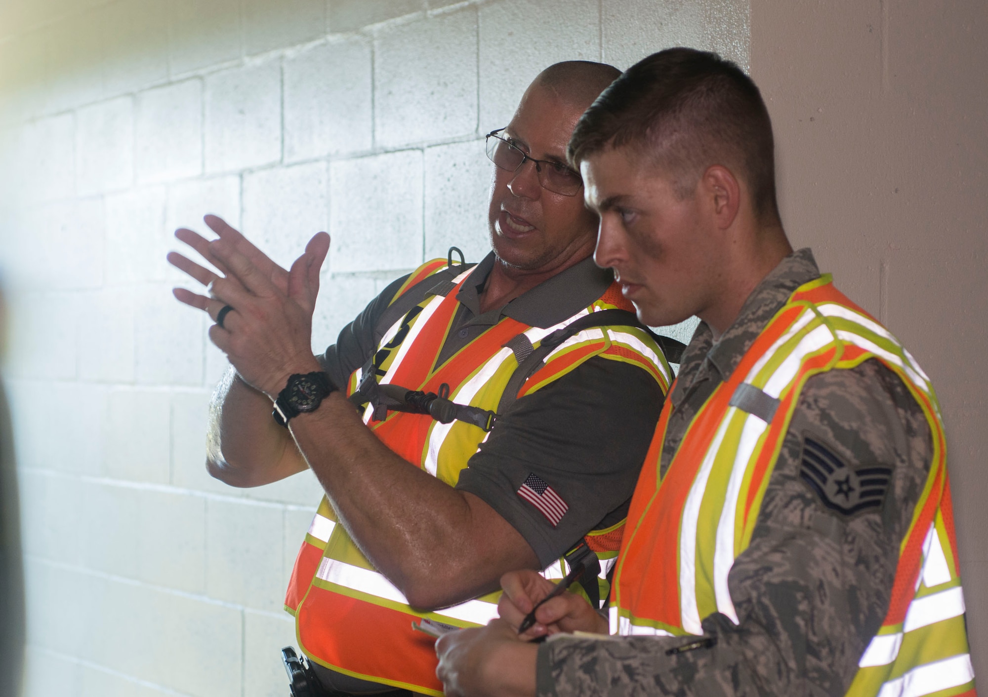 Evaluators from the 6th Security Forces Squadron talk about how teams performed and take notes during an active shooter exercise at MacDill Air Force Base, Fla., Aug. 8, 2019.