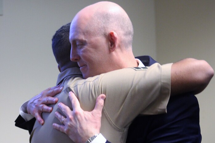 U.S. Marine Cpl. Stewart Rembert, a motor vehicle technician with Combat Logistics Battalion 8, Combat Logistics Regiment 2, 2nd Marine Logistics Group embraces FBI Special Agent Troy Sowers during the agent's retirement ceremony at the FBI Field Office in Knoxville, Tenn., Aug. 9, 2019. Sowers rescued days-old Rembert from a kidnapping in 1997 in Tacoma, Wash.