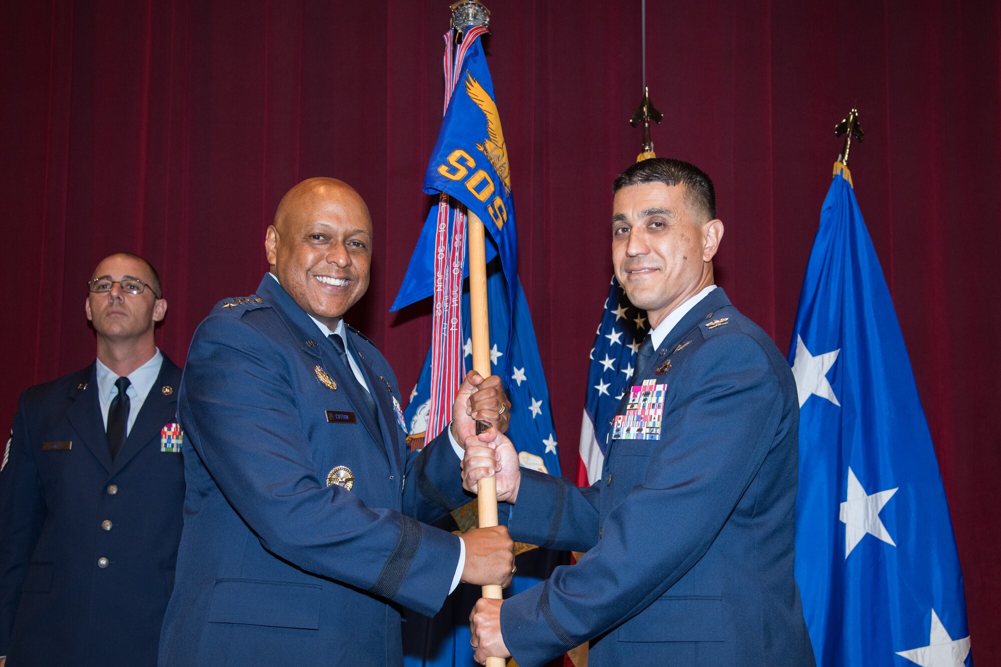 Lt. Gen. Anthony J. Cotton, Air University commander and president, passes the Squadron Officer School guidon to Col. Ricky L. Mills, SOS commander and commandant, during a change of command ceremony August 2, 2019, at Maxwell Air Force Base, Alabama. Mills served as the commander, 17th Training Wing, Goodfellow AFB, Texas, prior to taking command of SOS.