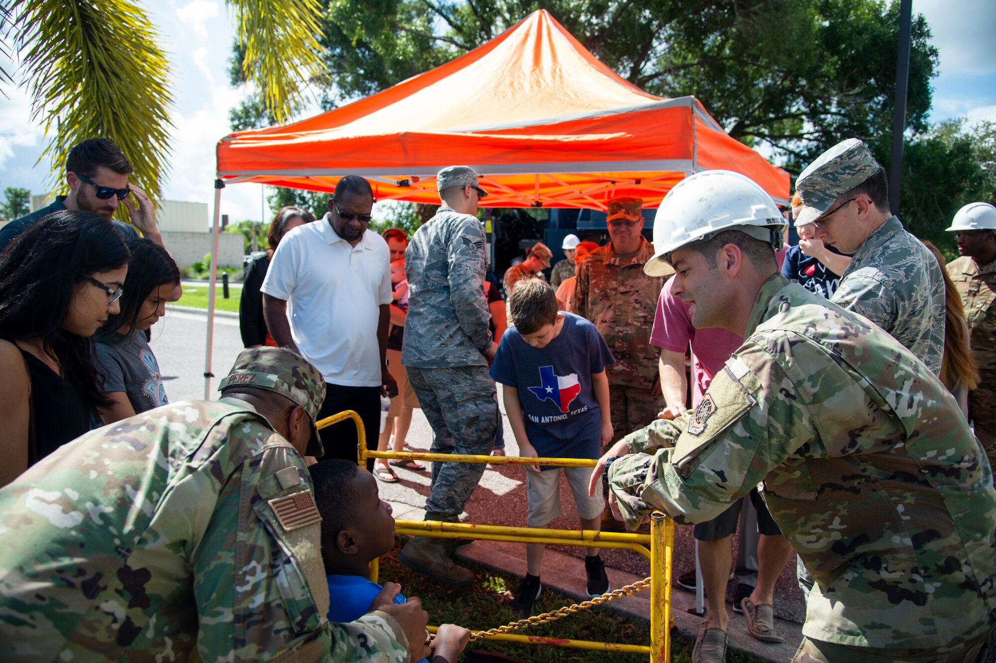 Airmen assigned to the 6th Communications Squadron and their families look at a manhole while learning about the mission of the cable team during an open house at MacDill Air Force Base, Fla., August 9, 2019.