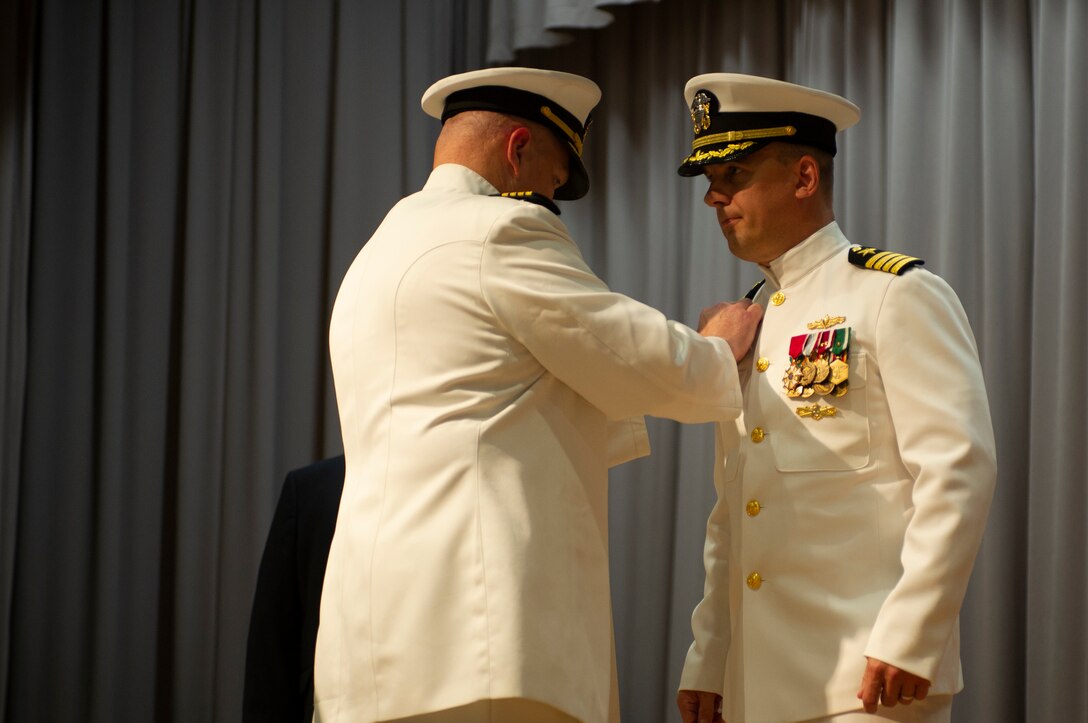 Capt. Brian D. Lawrence, left, pins the Supervisor of Shipbuilding Gulf Coast command pin to the uniform of Capt. Nathan A. Schneider. Schneider assumed command of SSGC during a change of command ceremony Aug. 12.