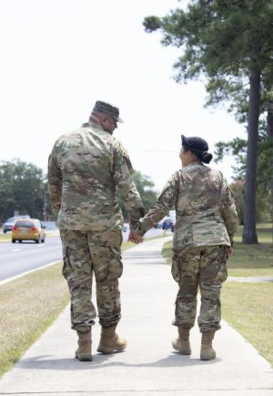 Staff Sgt. Joshua Mitchell, left, walks with his wife Spc. Eunjee Mitchell during the Fort Jackson Family Day on July 31. Spc. Mitchell recently graduated Basic Combat Training at the post. Her husband, an Army recruiter, enlisted his wife as she spent two years listening to him explain the benefits of military service to potential future Soldiers.