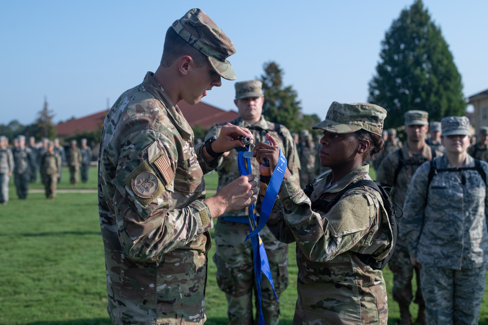 An Air Force Officer Training School flight chief assists his flight in the assembly of their newly earned pennant, Aug. 9, 2019, on Maxwell Air Force Base, Alabama. Officer Training School’s class 19-07 is comprised of more than 800 officer trainees and is more than twice the size of an average class at OTS. (U.S. Air Force photo by Airman 1st Class Charles Welty)