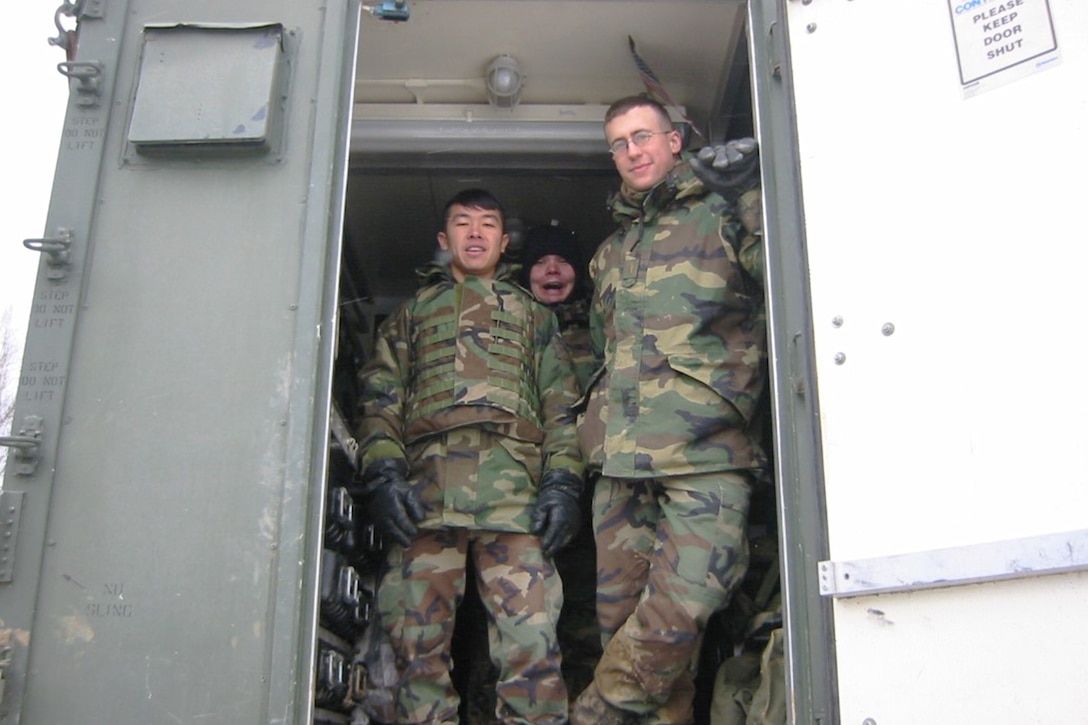 Army officers pose for a photo in the doorway of a building during a cold-weather exercise.