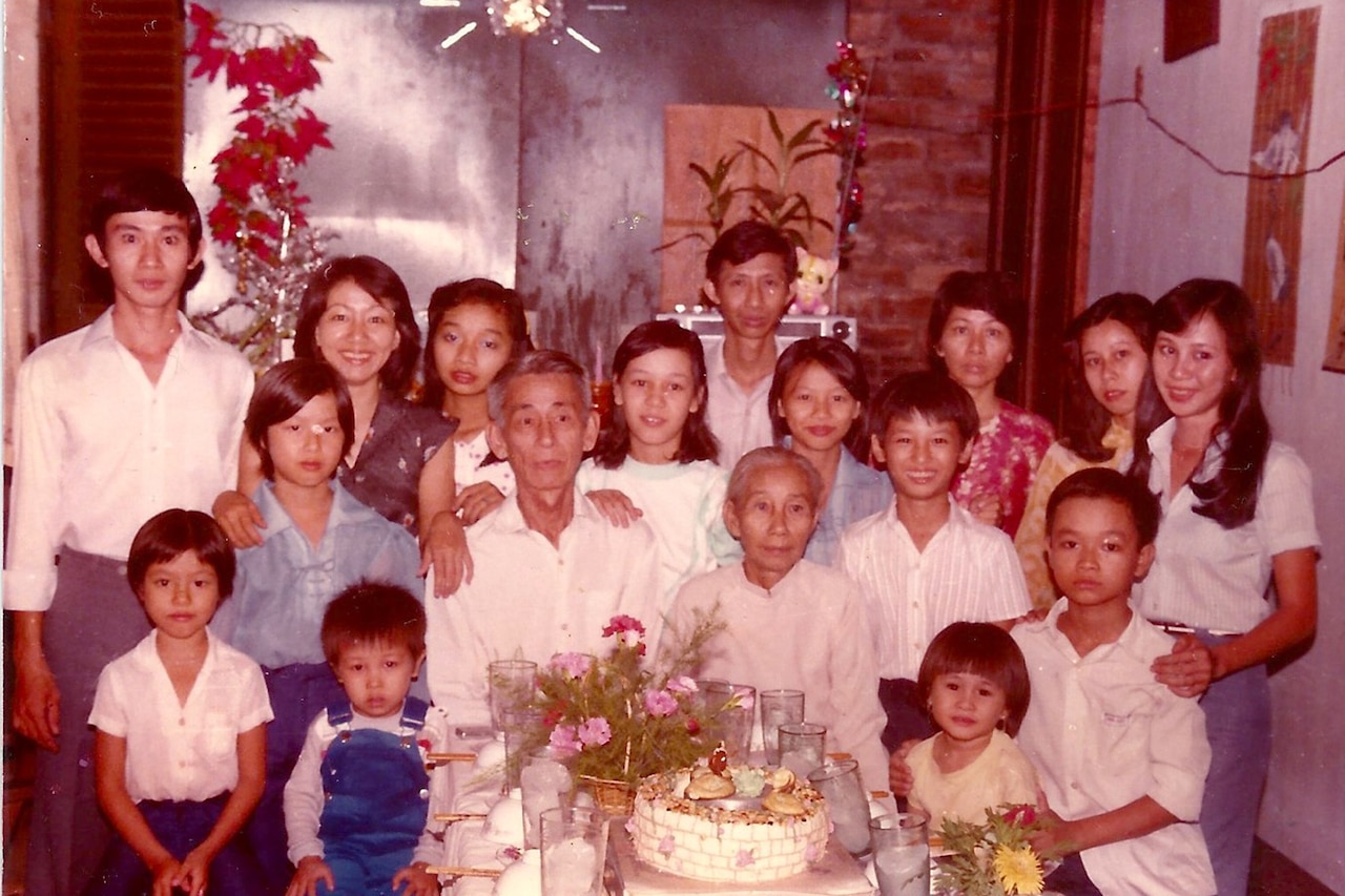 Family poses around a table for a family photo.