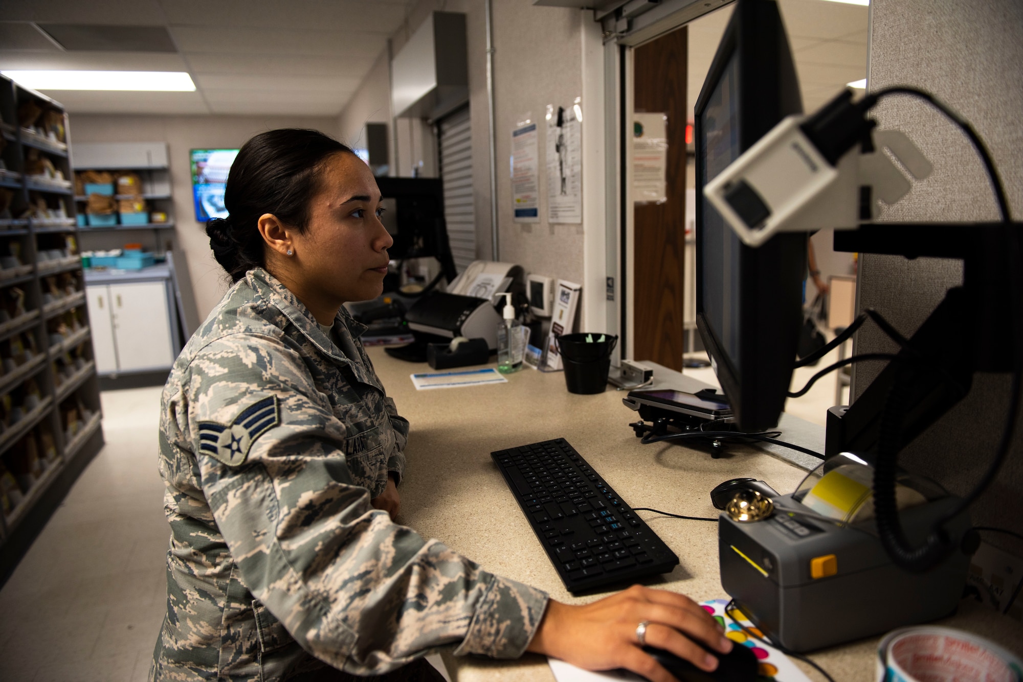 U.S. Air Force Senior Airman Alexandria Lara, 60th Diagnostics and Therapeutic Squadron pharmacy technician, searches customer information on a computer Aug. 12, 2019, at Travis Air Force Base, California. Lara works in the base exchange satellite pharmacy, where the team of seven refills 700 prescriptions a day.  (U.S. Air Force photo by Senior Airman Jonathon Carnell)