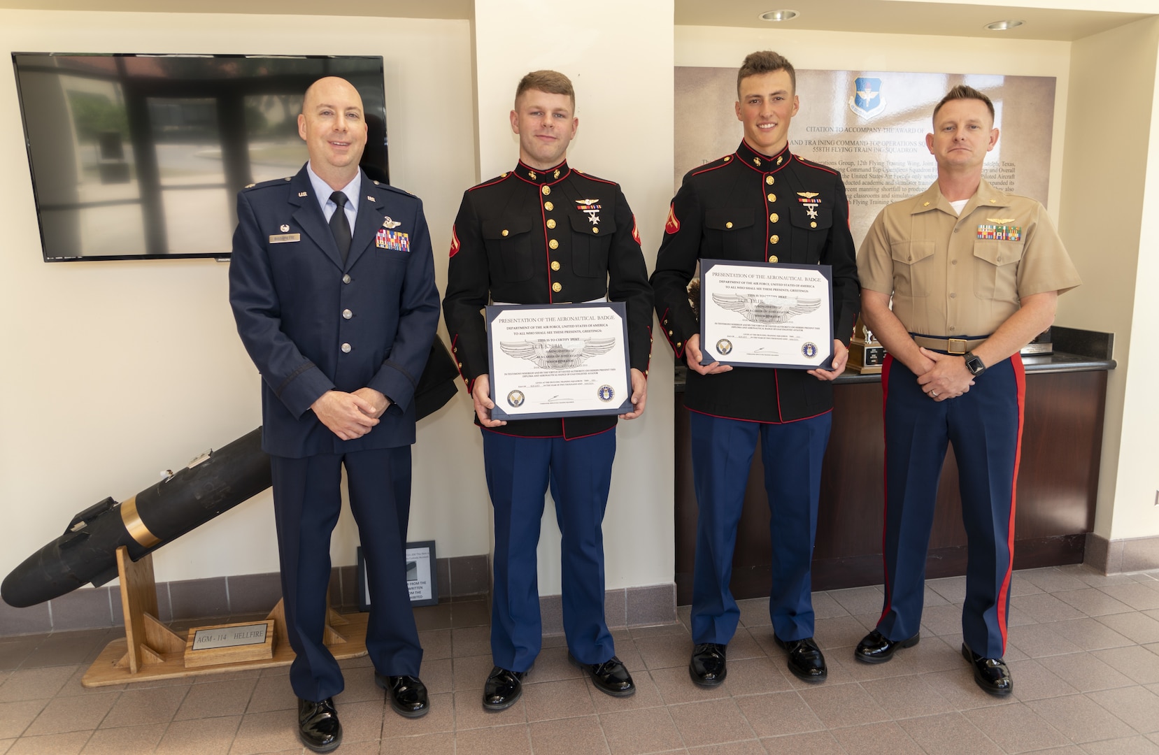 The Commander of 558 Flying Training Squadron (FTS) Lt. Col. Eric Bissonette (left) and Marine Liaison to 558 FTS Major Matthew Bailey (right) stand with two graduates from the 19-14 Basic Sensor Operator Course (BSOC) graduating class after a winging ceremony. LCpl Joshua (center left) and LCpl Tyler (center right) are the first two Marines to complete 558 FTS BSOC and go on to qualify on the MQ-9 Reaper Unmanned Aircraft System (UAS). The BSOC training program is a Air Force school which Marines have recently been doing a joint training with part of the 558 flight training squadron aboard Randolph Air Force Base