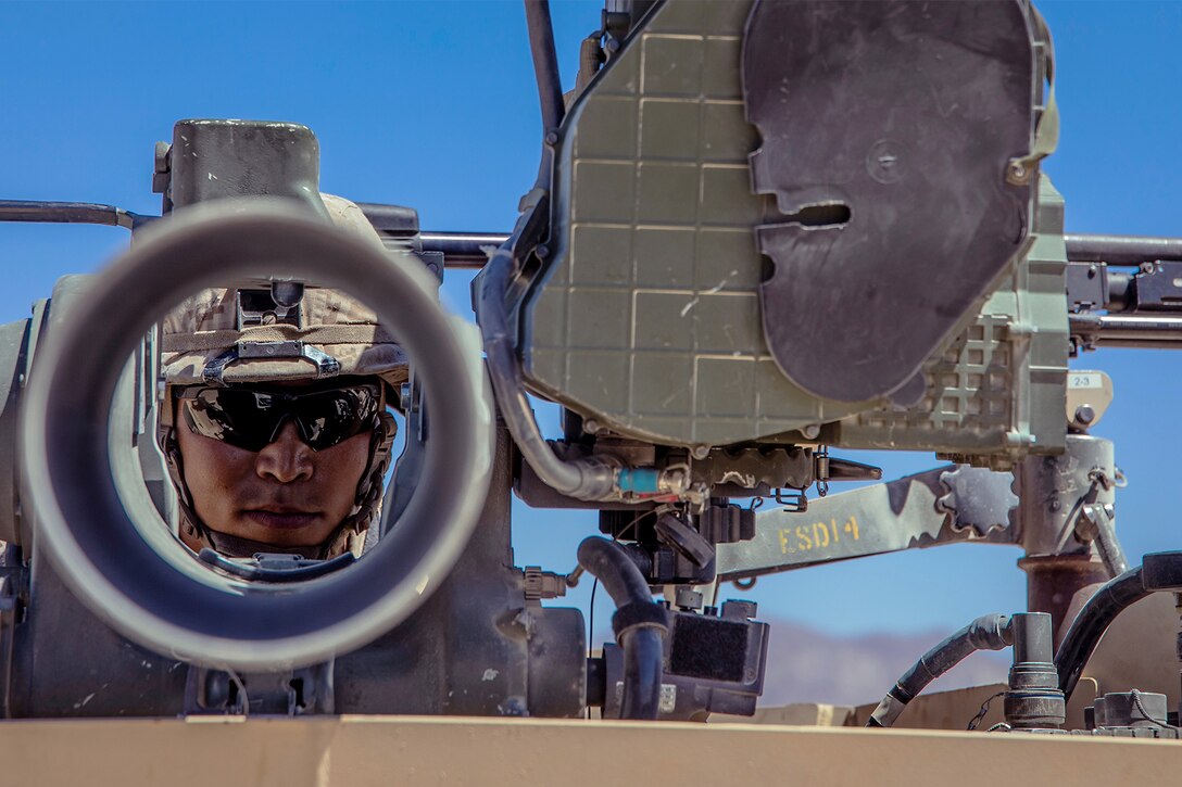 A Marine looks through a weapon during a maintenance check.