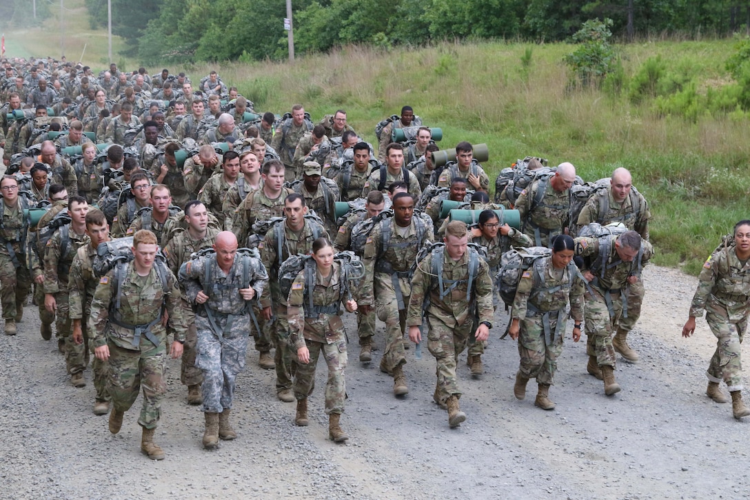 A large group of soldiers march along a road.