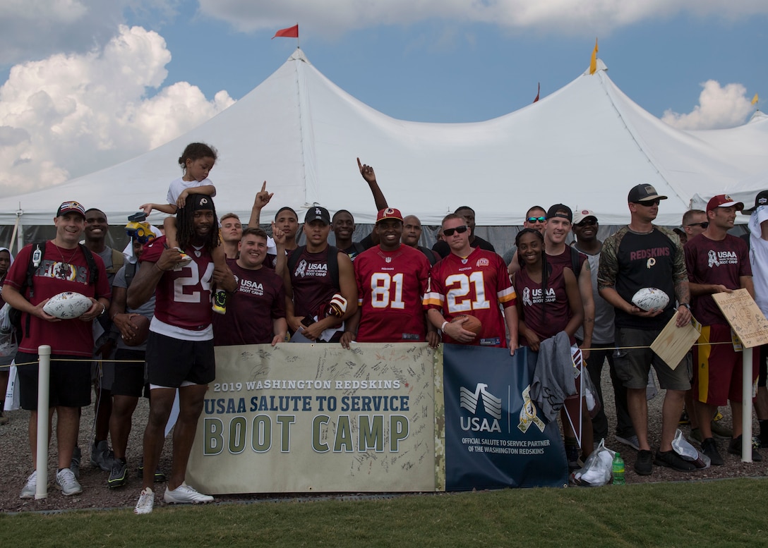 The National Football League’s Washington Redskins cornerback Josh Norman, poses with service members during USAA’s Salute to Service NFL Boot Camp event at the Bon Secours Washington Redskins Training Center, Richmond, Virginia, Aug. 6, 2019.