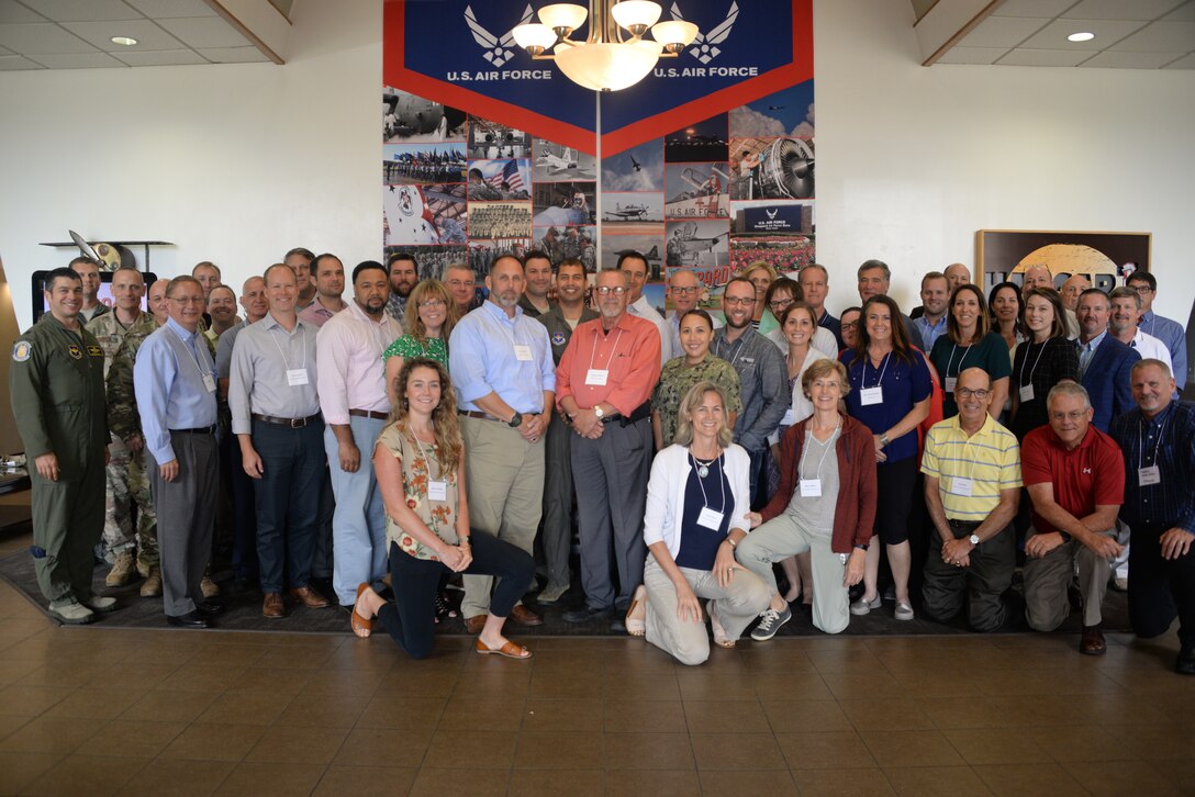 Group of representatives pose for a photo during a meeting to discuss  a variety of topics ranging from improving communication and relationships between wind industry companies, Department of Defense and local communities; technology and more.