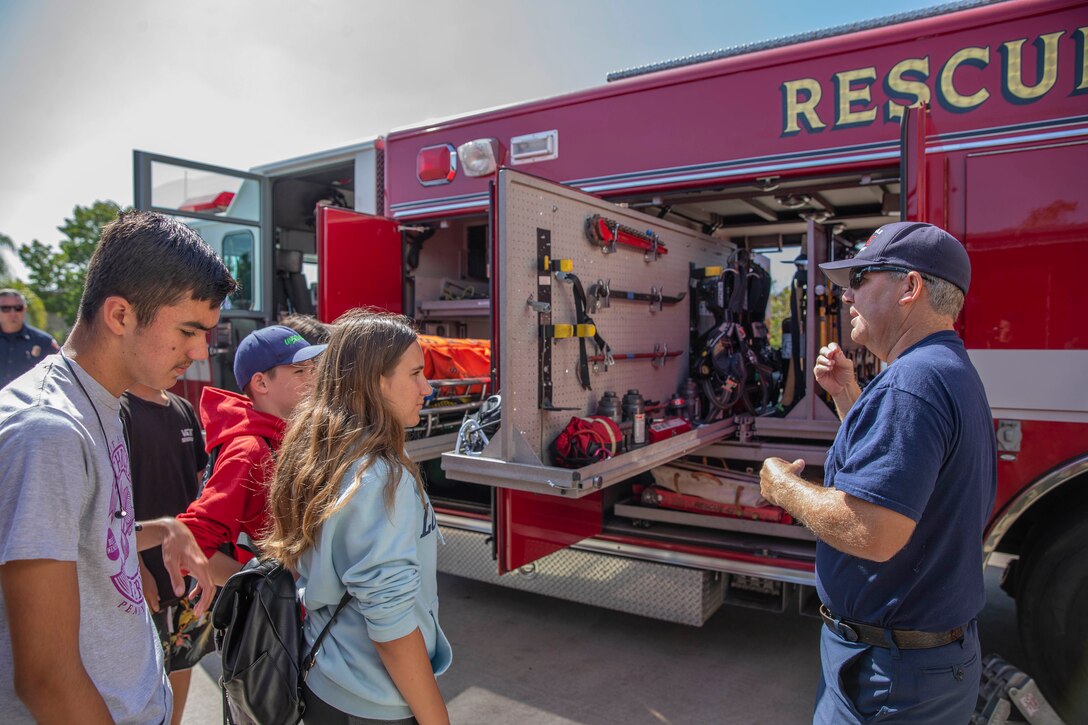 Kevin Brown, a Captain with the Miramar Fire Station, shows the youths from the Boys and Girls Club Miramar the essential tools used by firefighters at Marine Corps Air Station Miramar, Calif., Aug. 12. The Boys and Girls Club Miramar youths visited MCAS Miramar Station 61 to understand the importance of firefighting. (Marine Corps photo by Lance Cpl. Cheng Chang)