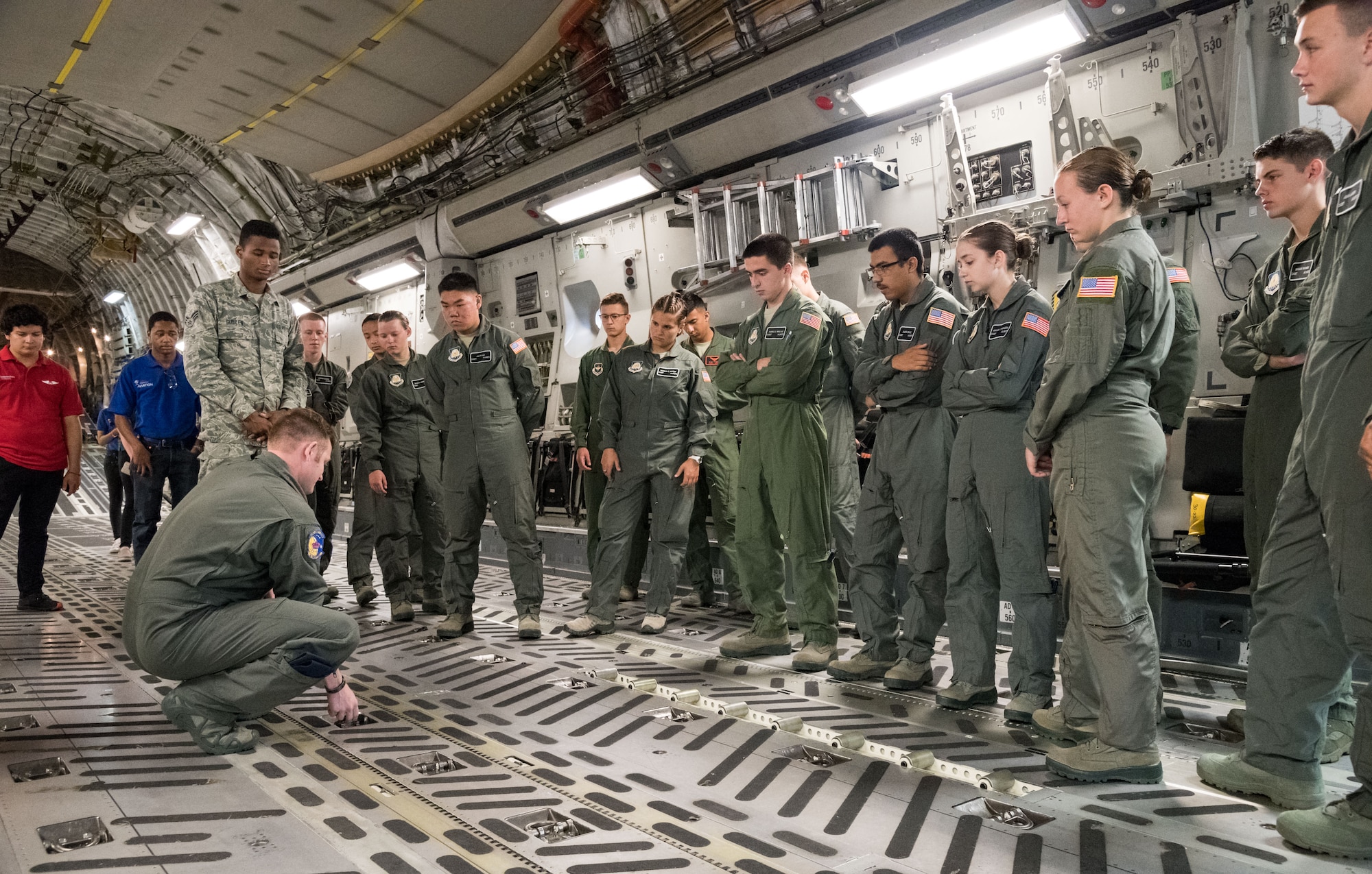 Tech. Sgt. Jordan Rayman, 3rd Airlift Squadron C-17A Globemaster III loadmaster, demonstrates to Air Force Junior Reserve Officers’ Training Corps cadets how cargo floor rollers are deployed July 23, 2019, at Dover Air Force Base, Del. Cadets who attended the AFJROTC Summer Flight Academy at Delaware State University in Dover, met with C-17 aircrew members during their half-day tour of the base. (U.S. Air Force photo by Roland Balik)