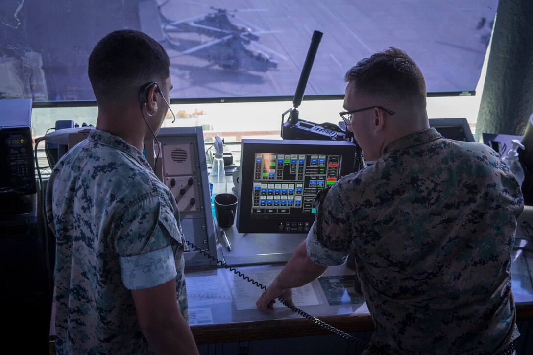 U.S. Marine Lance Cpl. Kareem Hitt, an air traffic controller with Headquarters and Headquarters Squadron, Marine Corps Air Station Camp Pendleton, teaches Lance Cpl. Nathan Reichwein, an air traffic controller with H&HS, MCAS Camp Pendleton, how to direct air traffic at MCAS Camp Pendleton, Marine Corps Base Camp Pendleton, California, Aug. 6, 2019. Hitt joined the Marine Corps in August 2017, and has been serving at the air traffic control tower at MCAS Camp Pendleton since June 2018. Hitt was recently recognized as the air traffic controller of the third quarter, fiscal year 2019. (U.S Marine Corps photo by Lance Cpl. Andrew Cortez)