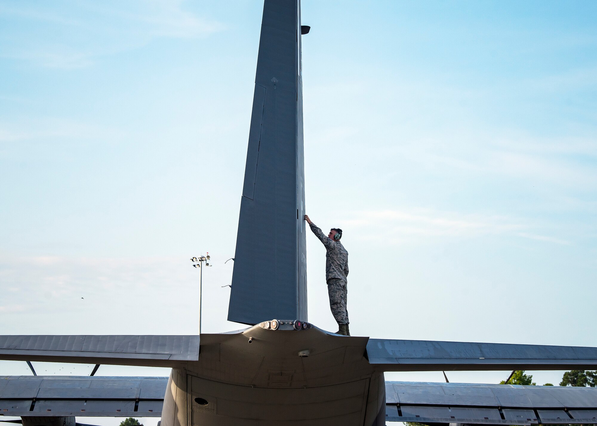 An Airman from the 71st Aircraft Maintenance Unit (AMU) inspects the tail fin of an HC-130J Combat King II Aug. 13, 2019, at Moody Air Force Base, Ga. Airmen from the 71st AMU perform various tasks prior to takeoff to ensure the aircraft is performing optimally to complete its mission of supporting the 71st Rescue Squadron. Those tasks consist of: pre-flight inspection, removing plugs and cover, repairing any problems found during crew pre-flight checks as well as marshaling the aircraft for takeoff. (U.S. Air Force photo by Airman 1st Class Eugene Oliver)