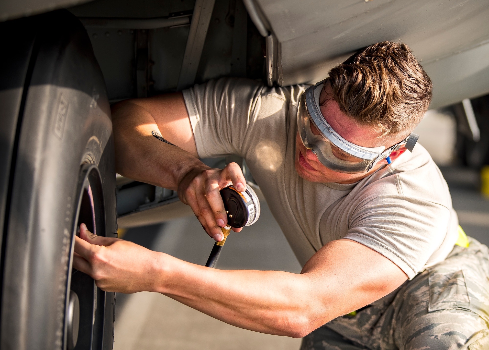 Airman 1st Class Branson Bounds, 71st Aircraft Maintenance Unit (AMU) crew chief, checks the pressure for a tire on an HC-130J Combat King II, Aug. 13, 2019, at Moody Air Force Base, Ga. Airmen from the 71st AMU perform various tasks prior to take off to ensure the aircraft is performing optimally to complete its mission of supporting the 71st Rescue Squadron. Those tasks consist of: pre-flight inspection, removing plugs and cover, repairing any problems found during crew pre-flight checks as well as marshaling the aircraft for takeoff. (U.S. Air Force photo by Airman 1st Class Eugene Oliver)