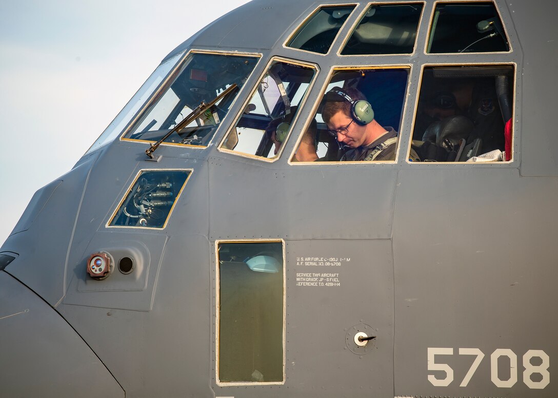A pilot from the 71st Rescue Squadron (RQS), sits in the cockpit of an HC-130J Combat King II, Aug. 13, 2019, at Moody Air Force Base, Ga. Airmen from the 71st Aircraft Maintenance Unit perform various tasks prior to takeoff to ensure the aircraft is performing optimally to complete its mission of supporting the 71st RQS. Those tasks consist of: pre-flight inspection, removing plugs and cover, fueling the aircraft, repairing any problems found during crew pre-flight checks as well as marshaling the aircraft for takeoff.  (U.S. Air Force photo by Airman 1st Class Eugene Oliver)