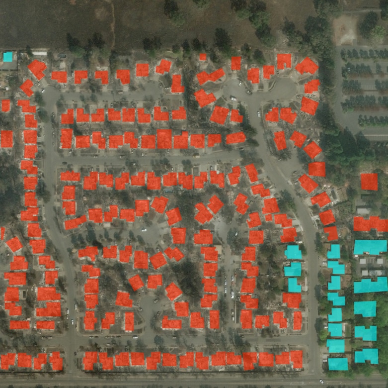 Satellite photo of a residential subdivision with red and blue rectangles marking damaged and undamaged homes, respectively.