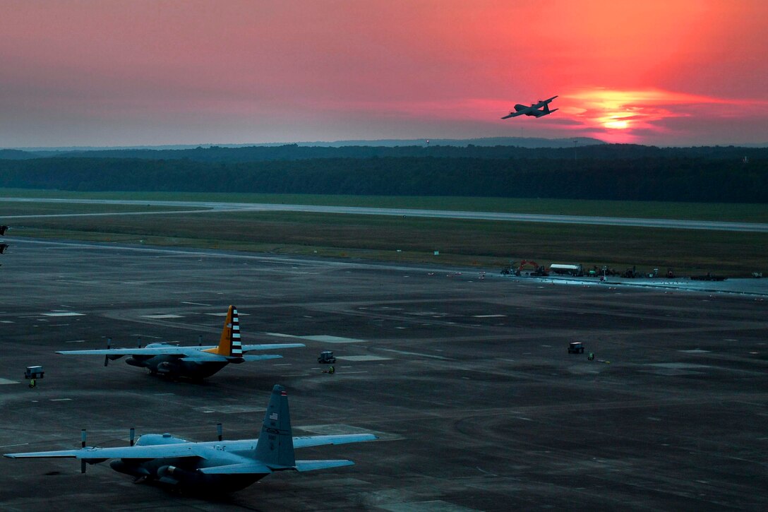 A plane takes off at sunset.