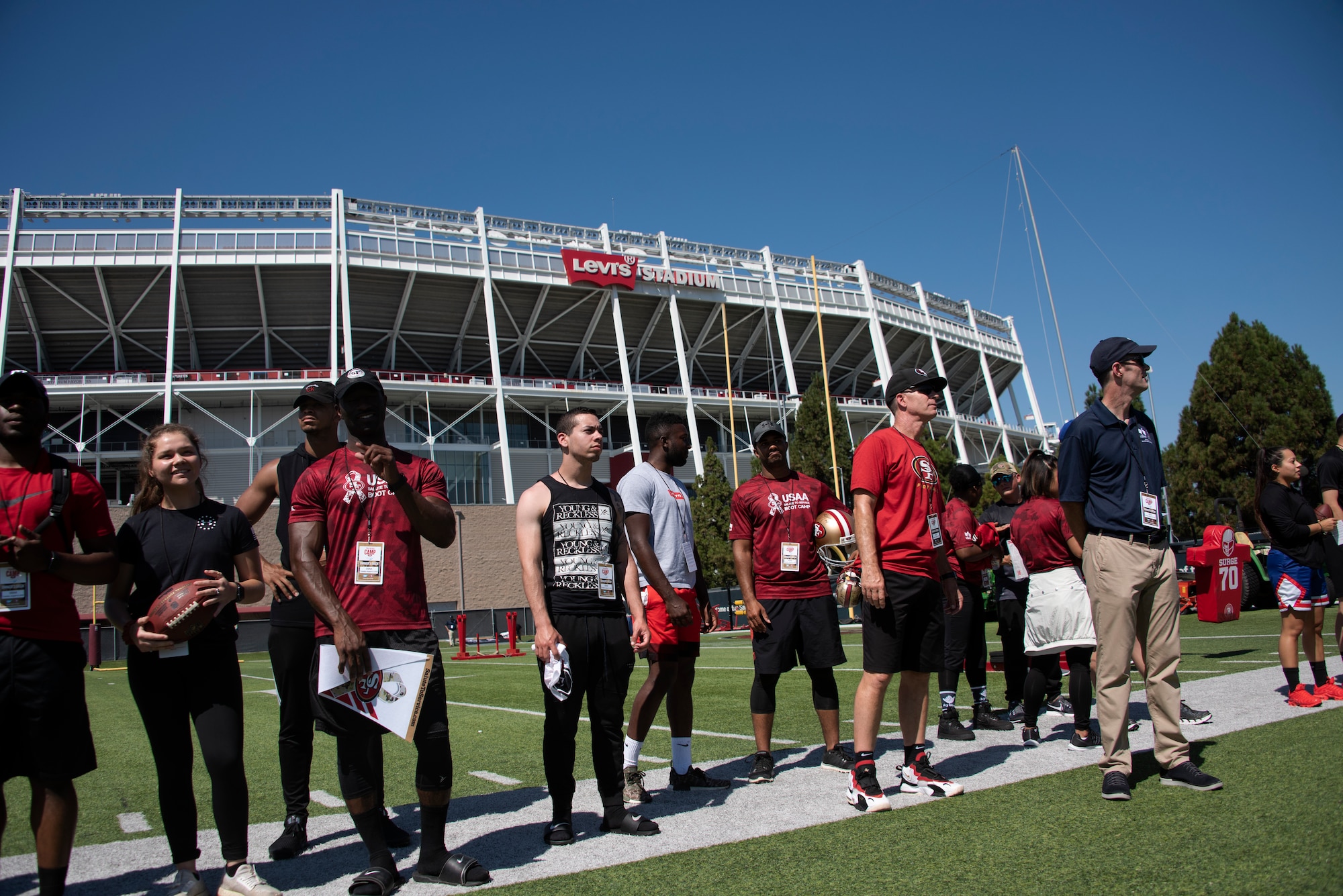 U.S. Airmen from Travis Air Force Base, California, watch as the San Francisco 49ers practice Aug. 13, 2019, during the Salute to Service Boot Camp in Santa Clara, California. Fifty Airmen attended the event from numerous units. The event provided Airmen with an opportunity to interact with NFL players and compete against one another in a variety of athletic drills. (U.S. Air Force photo by Tech. Sgt. James Hodgman)