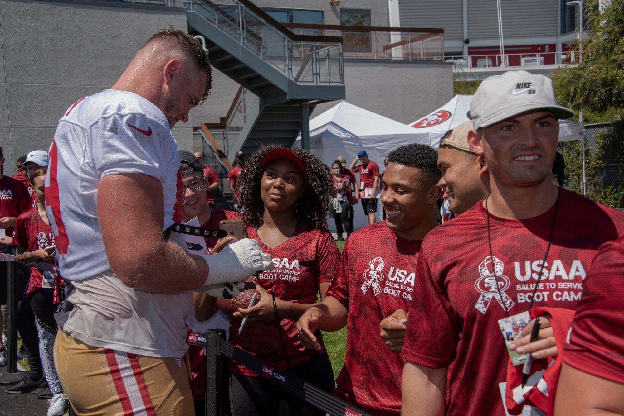 San Francisco 49ers offensive lineman Mike McGlinchey signs autographs for Airmen from Travis Air Force Base, California, Aug. 13, 2019, during the Salute to Service Boot Camp event in Santa Clara, California. The event provided Airmen with an opportunity to interact with NFL players and compete against one another in a variety of athletic drills. (U.S. Air Force photo by Tech. Sgt. James Hodgman)