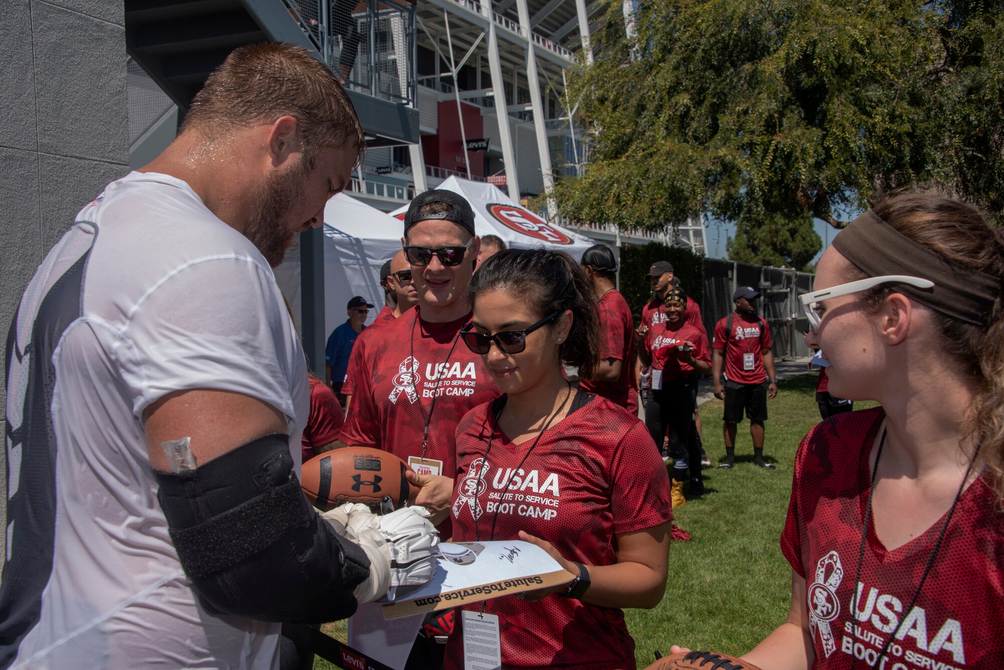 San Francisco 49ers offensive lineman Ben Garland signs autographs for Airmen from Travis Air Force Base, California, Aug. 13, 2019, during the Salute to Service Boot Camp event in Santa Clara, California. The event provided Airmen with an opportunity to interact with NFL players and compete against one another in a variety of athletic drills. (U.S. Air Force photo by Tech. Sgt. James Hodgman)