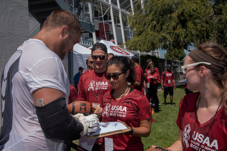 San Francisco 49ers offensive lineman Ben Garland signs autographs for Airmen from Travis Air Force Base, California, Aug. 13, 2019, during the Salute to Service Boot Camp event in Santa Clara, California. The event provided Airmen with an opportunity to interact with NFL players and compete against one another in a variety of athletic drills. (U.S. Air Force photo by Tech. Sgt. James Hodgman)