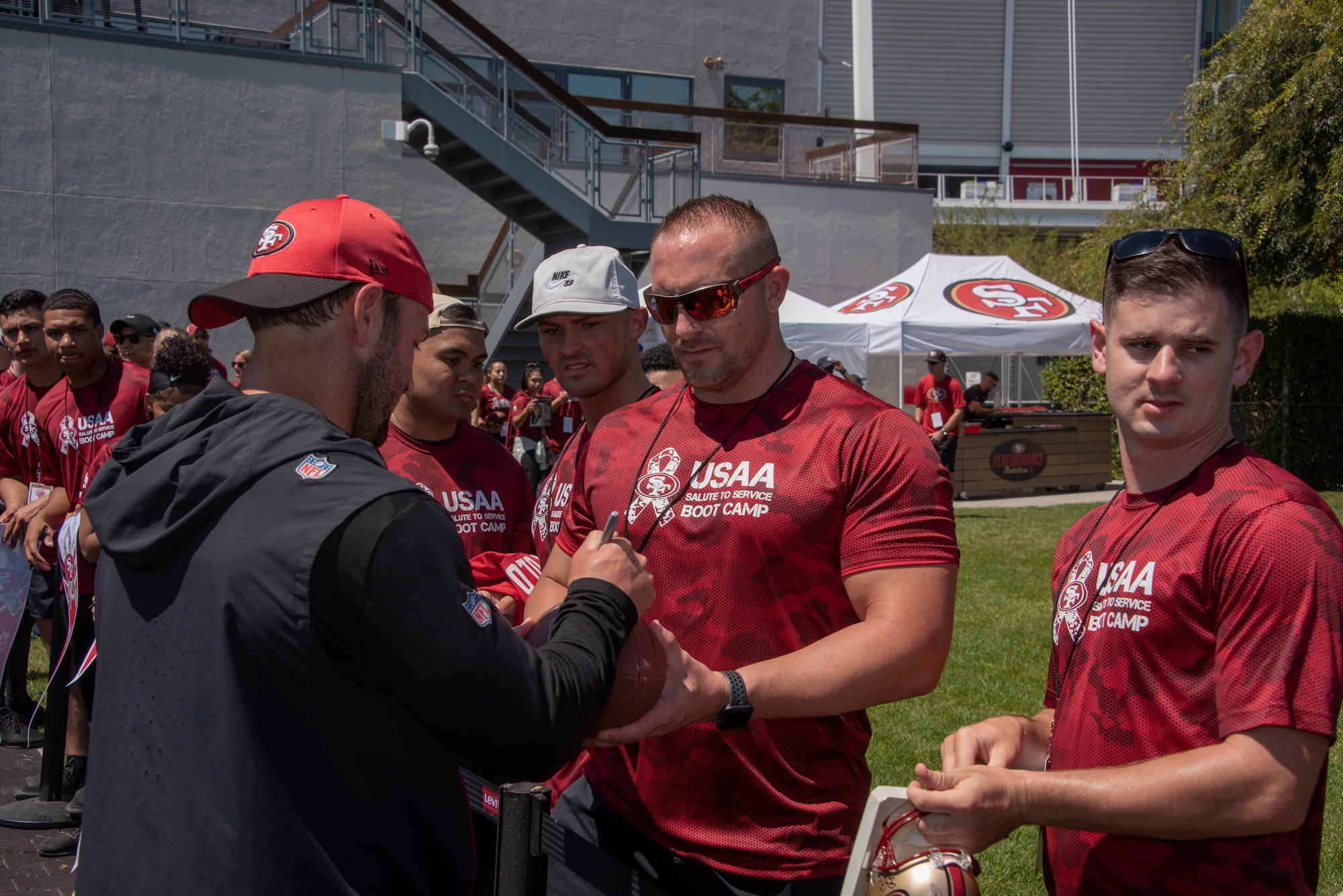 San Francisco 49ers wide receivers coach Wes Welker signs autographs for Airmen from Travis Air Force Base, California, Aug. 13, 2019, during the Salute to Service Boot Camp event in Santa Clara, California. The event provided Airmen with an opportunity to interact with NFL players and compete against one another in a variety of athletic drills. (U.S. Air Force photo by Tech. Sgt. James Hodgman)
