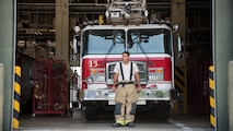 U.S. Air Force Airman 1st Class Adam Cardona, a 35th Civil Engineer fire protection journeyman, pauses for a photo in front of a fire truck at Misawa Air Base, Japan, Aug. 7, 2019. Cardona’s leadership makes training exercises a top priority due to the base’s location, enhancing his professional growth. (U.S. Air Force photo by Senior Airman Collette Brooks)
