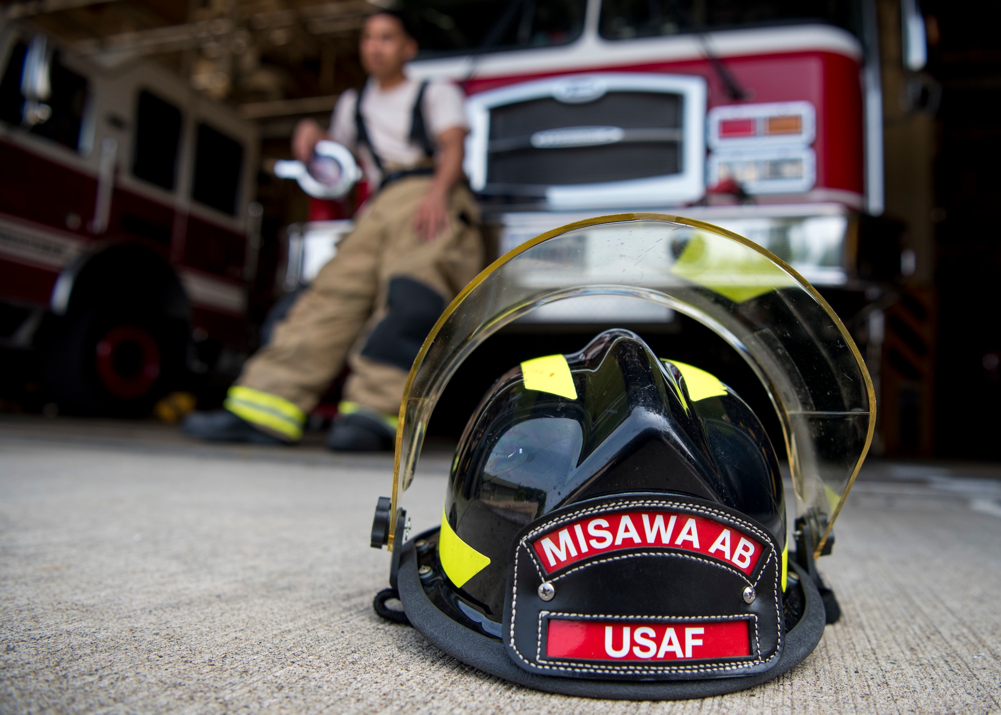 USAF Cardona’s fire protection helmet sits on the ground in front of a fire truck at Misawa Air Base, Japan, Aug. 7, 2019. Cardona expressed Misawa City residents made him instantly feel like a part of the community due to their generosity, kindness and easy going personalities. The demeanor of local Japanese members inspired Cardona to be more humble, understanding and thoughtful when interacting with others. (U.S. Air Force photo by Senior Airman Collette Brooks)