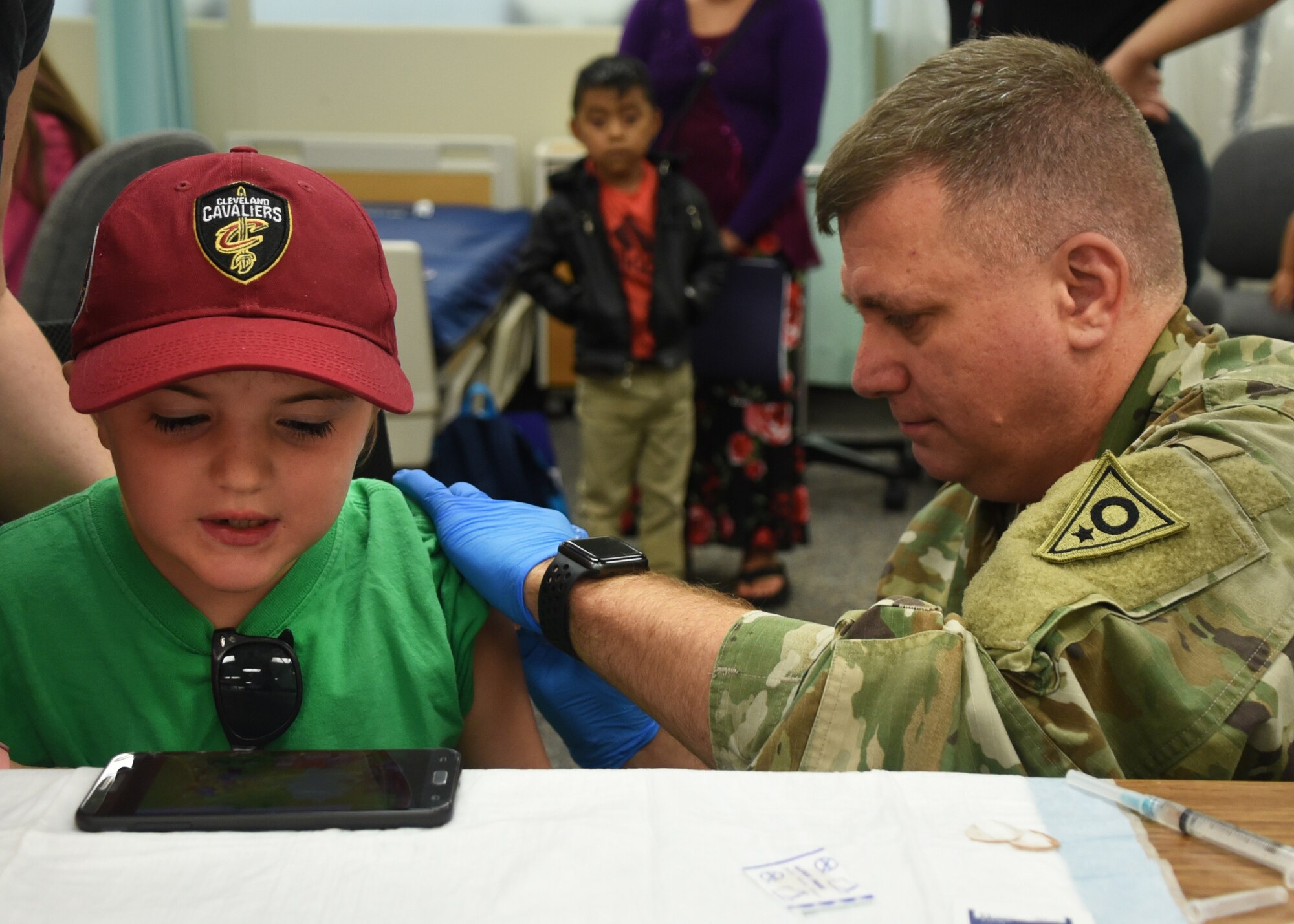 A soldier from the Ohio Army National Guard gives a child an immunization shot as part of GuardCare Weekend Aug. 10, 2019, at the Buckeye Career Center, New Philadelphia, Ohio. During the event both service members from the Ohio Army and Air National Guard provided health services to the local and surrounding New Philadelphia population. (U.S. Air National Guard photo by Senior Airman Gwendalyn Smith)
