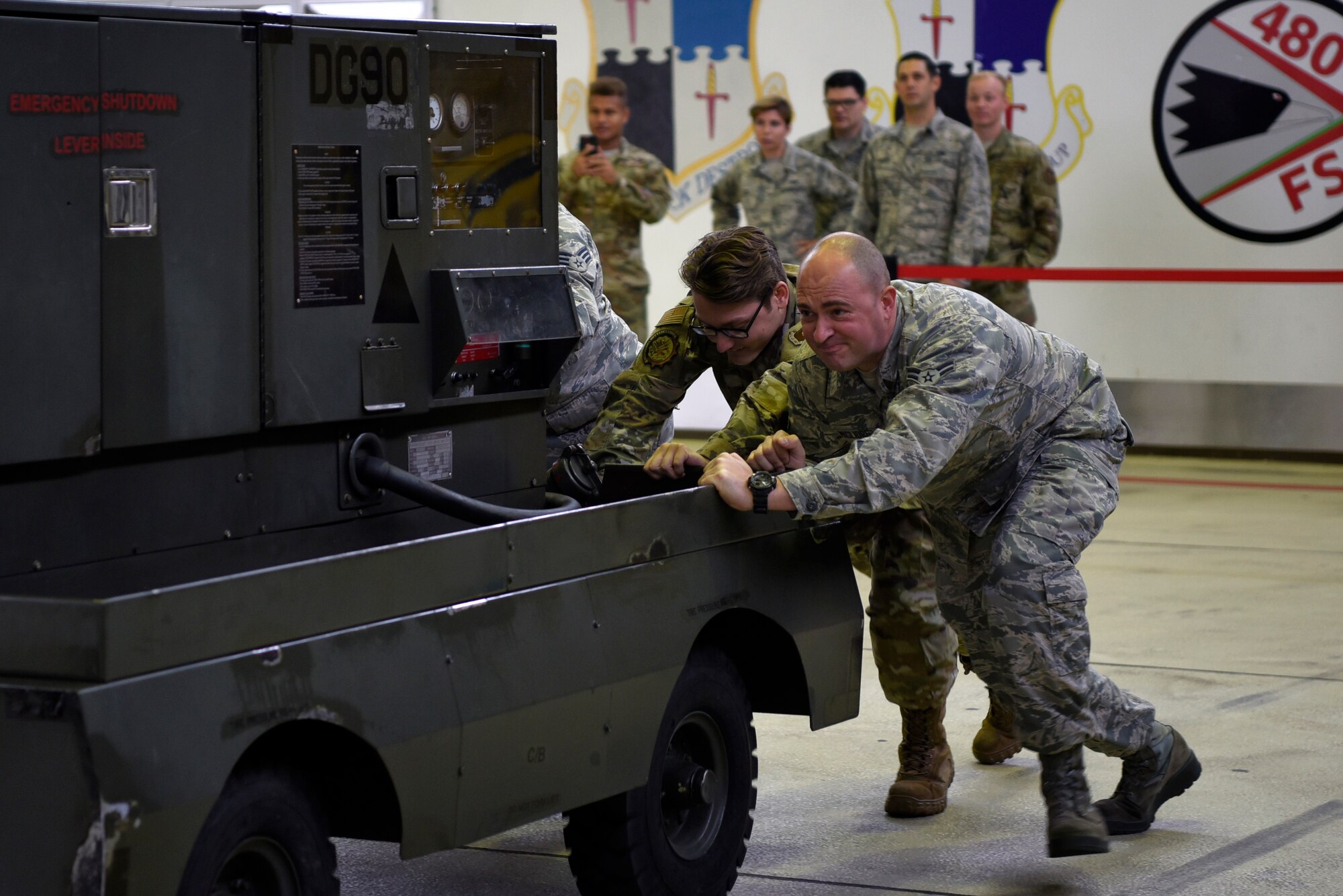 U.S. Air Force 52nd Maintenance Group Airmen push a generator in an "86 push-pull" game during the 52nd MXG Olympics at Spangdahlem Air Base, Germany, Aug. 15, 2019. The first 52nd MXG Olympics took place in 2018 and is scheduled to be an annual morale event. (U.S. Air Force photo by Airman 1st Class Valerie Seelye)