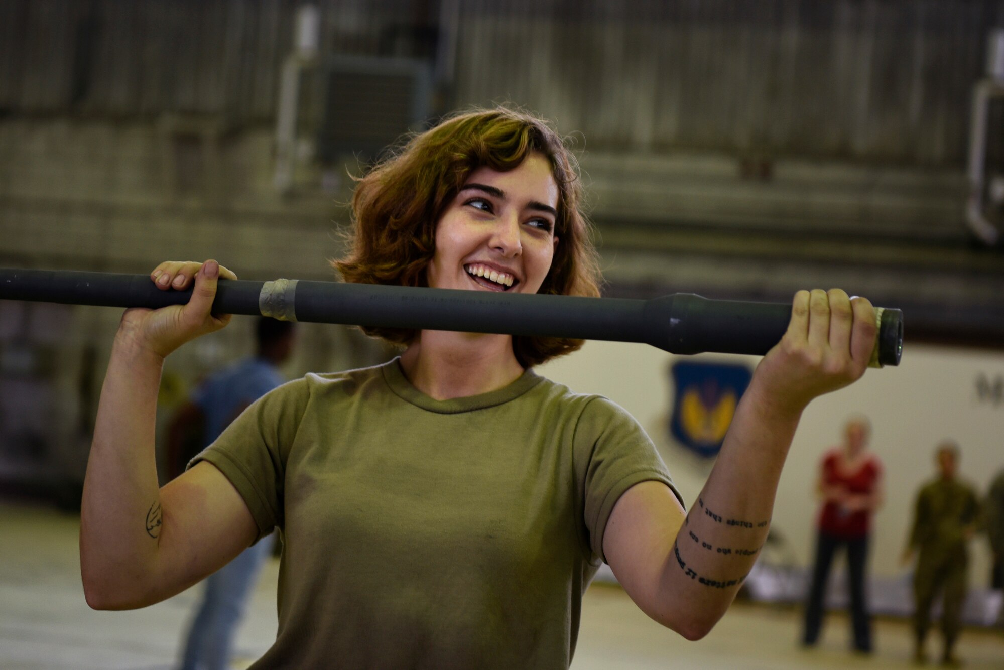 U.S. Air Force Airman 1st Class Rebekah Wilhelmy, 52nd Maintenance Squadron aerospace propulsion apprentice, competes in the "guns with guns" game during the 52nd Maintenance Group Olympics at Spangdahlem Air Base, Germany, Aug. 15, 2019. During the game, each participant tried to keep their arms raised as long as possible while holding a gun barrel. (U.S. Air Force photo by Airman 1st Class Valerie Seelye)