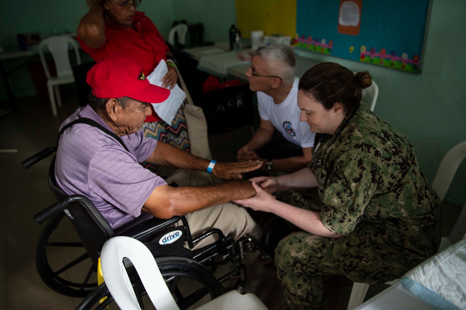 A military doctor examines a patient.