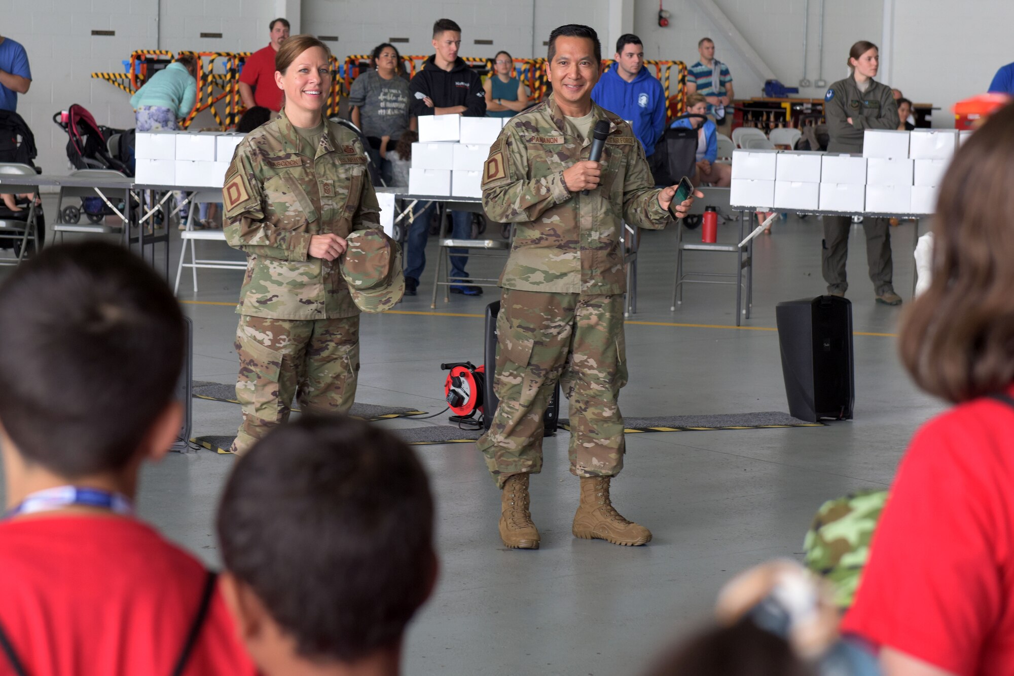 Chief Master Sgt. Kathi Glascock, 100th Air Refueling Wing command chief, and Col. Troy Pananon, 100th ARW commander, speak to children at the ‘kids deployment line’ at RAF Mildenhall, England, Aug. 9, 2019. Pananon and Glascock took turns speaking to the children and getting them ready to begin their day of deployment activities. (U.S. Air Force photo by Senior Airman Benjamin Cooper)