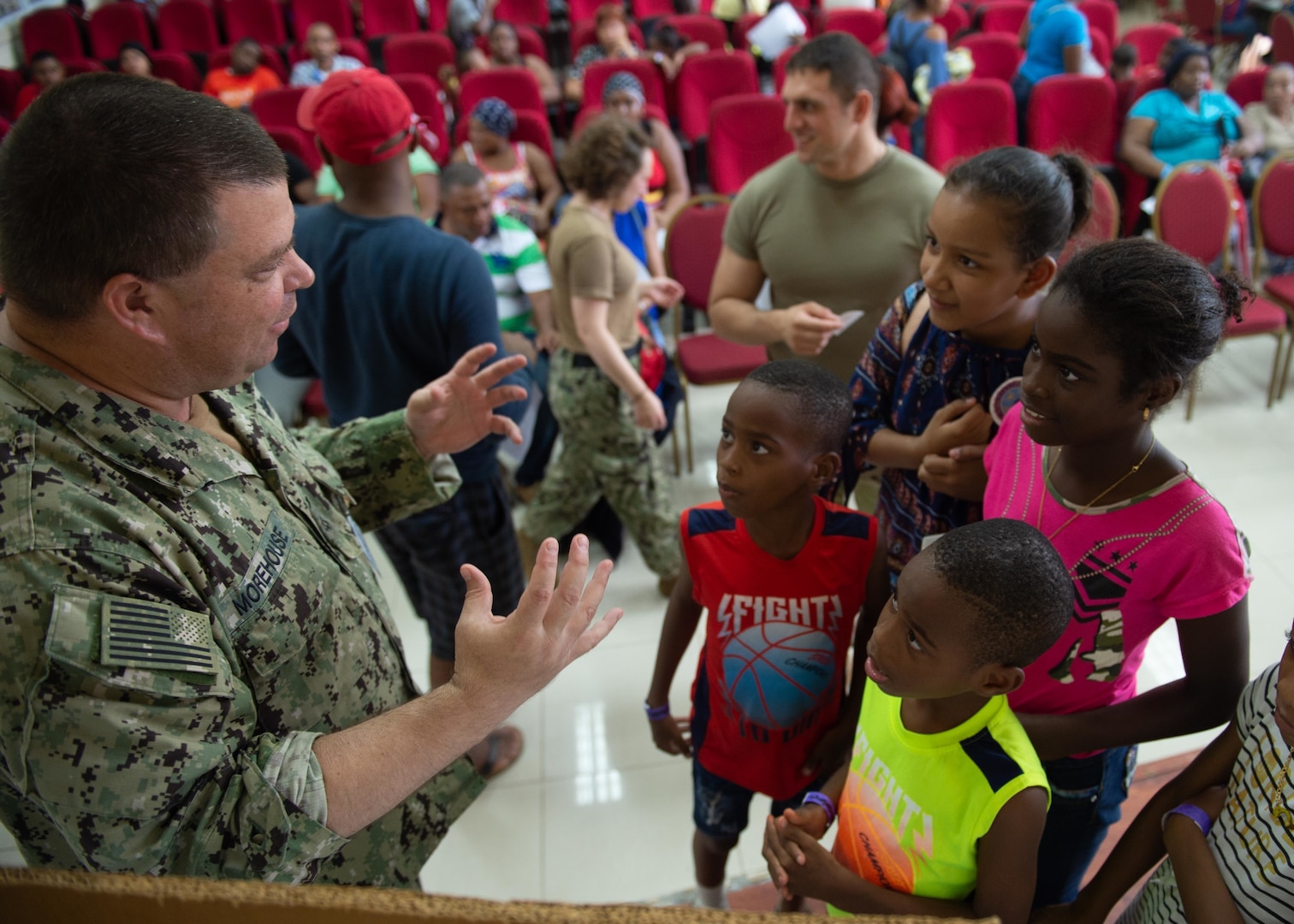 A U.S. military person speaks to children.