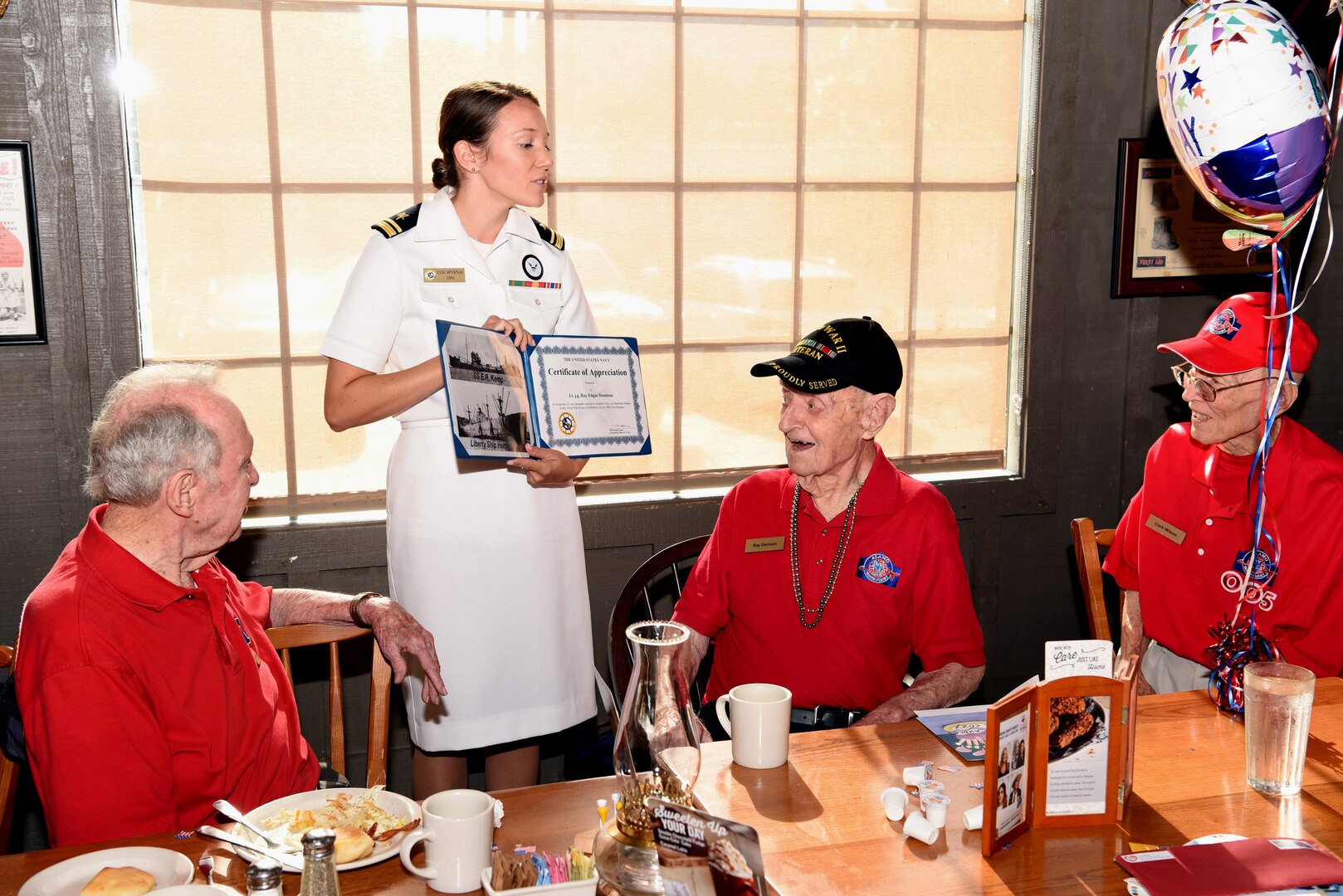 Navy Lt. j.g. Kathleen Spyrnal, an officer programs operations officer assigned to Navy Recruiting District San Antonio, presented a certificate of appreciation to World War II Merchant Marine Ray Denison during an Alamo Honor Flight Breakfast Aug. 14. Attended by other WWII veterans, the breakfast also served as a venue to celebrate Denison’s 100th birthday.