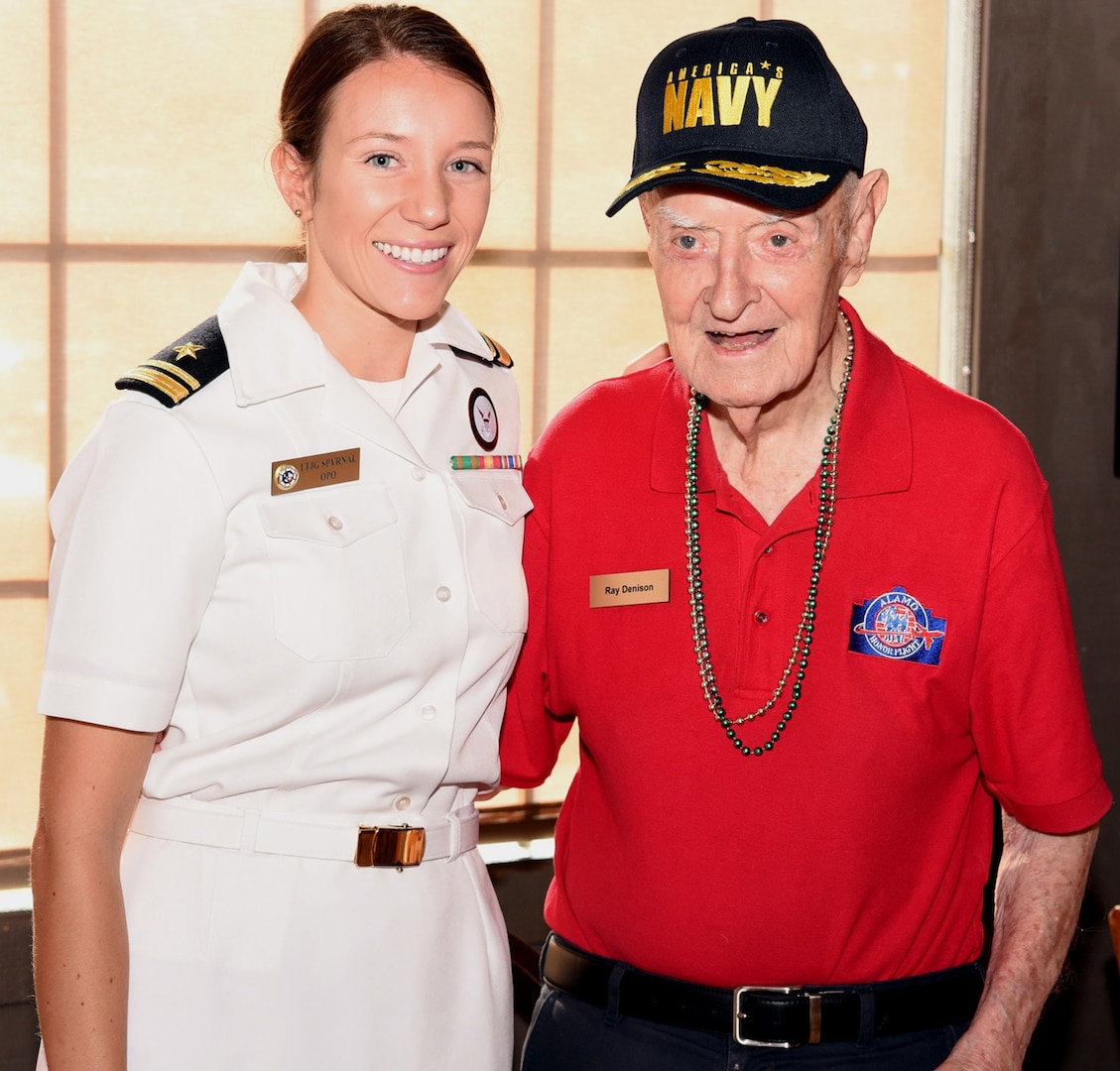 Navy Lt. j.g. Kathleen Spyrnal, an officer programs operations officer assigned to Navy Recruiting District San Antonio, poses with WWII Merchant Marine Ray Denison during an Alamo Honor Flight Breakfast at a local restaurant Aug. 14. Attended by other WWII veterans, the breakfast also served as a venue to celebrate Denison’s 100th birthday. Denison, a long-time city resident and native of Eagle Pass, Texas, joined the U.S. Merchant Marines on Memorial Day 1942 and served till November 1945.  While serving, he held a reserve commission as a lieutenant junior grade in the U.S. Navy.