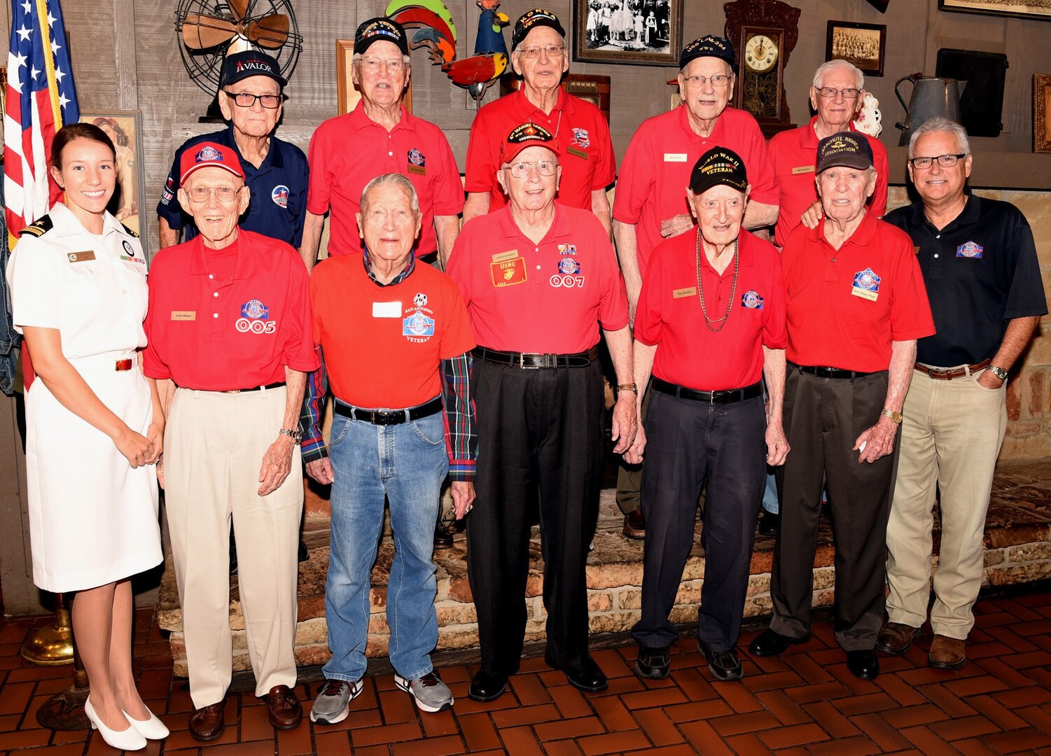 Navy Lt. j.g. Kathleen Spyrnal, an officer programs operations officer assigned to Navy Recruiting District San Antonio, poses with members of Alamo Honor Flight during their monthly breakfast Aug. 14. The breakfast also served as a venue to celebrate WWII Merchant Marine Ray Denison’s 100th birthday (first row, third from right).