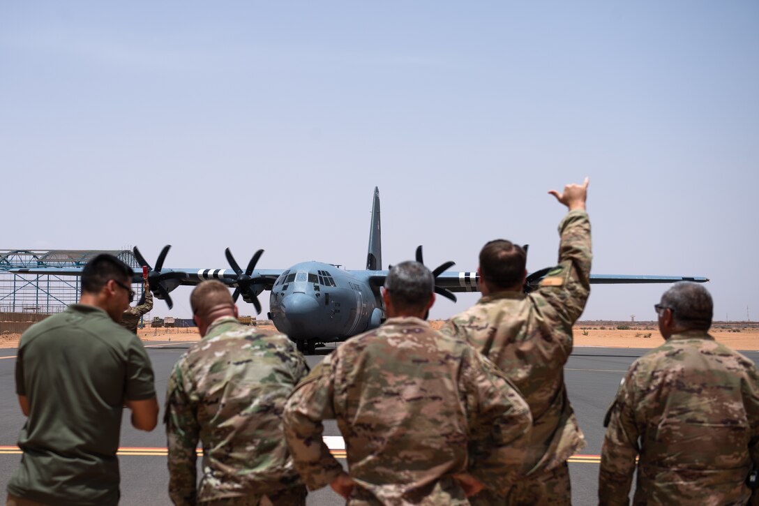 U.S. Air Force Airmen assigned to the 409th Air Expeditionary Group watch as a C-130J Super Hercules taxis in at Nigerien Air Base 201, Agadez, Niger, Aug. 3, 2019. The C-130 landing marked the next step in airfield evaluations by starting Visual Flight Rules operations at the base. (U.S. Air Force photo by Staff Sgt. Devin Boyer)