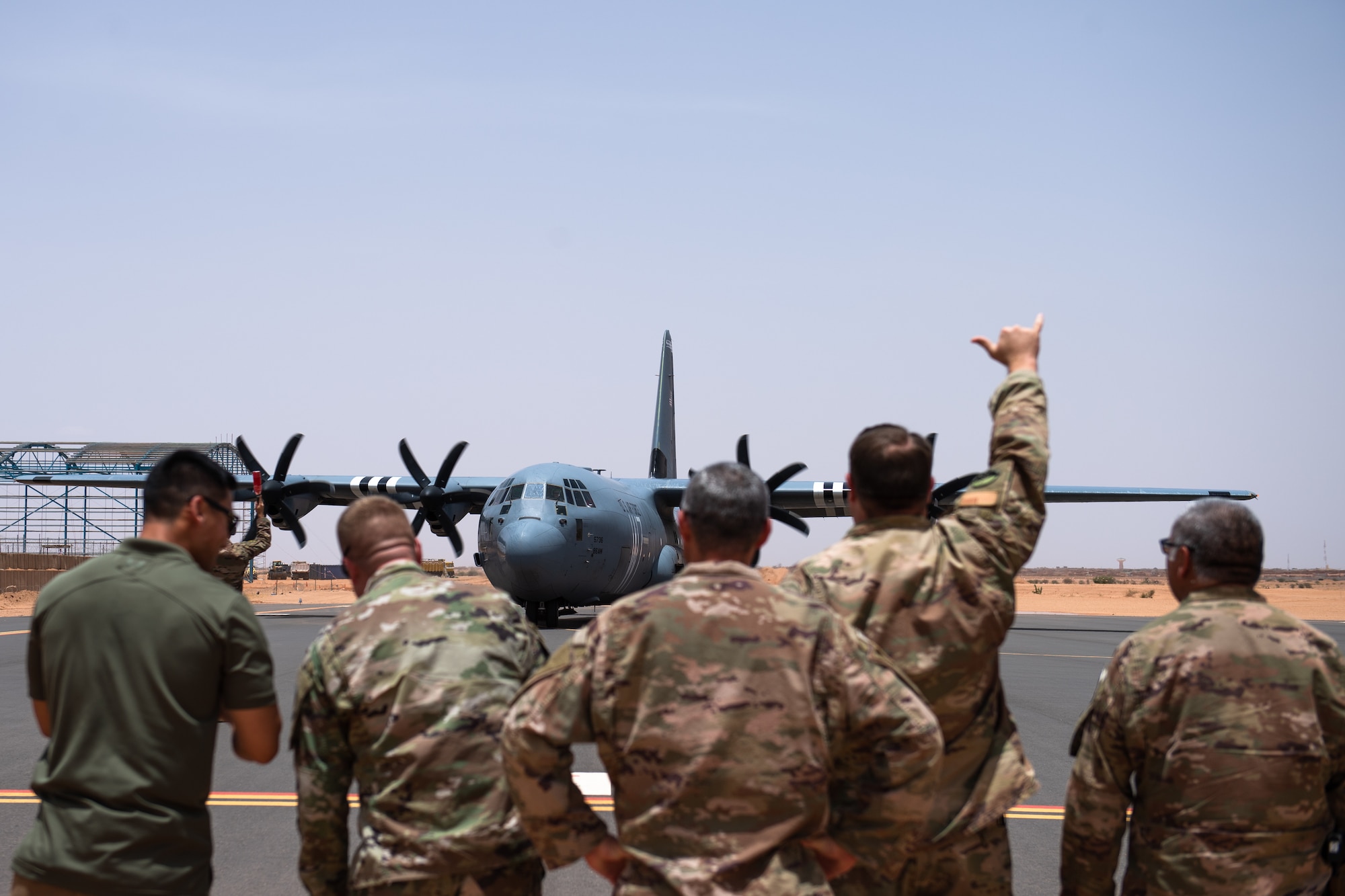 U.S. Air Force Airmen assigned to the 409th Air Expeditionary Group watch as a C-130J Super Hercules taxis in at Nigerien Air Base 201, Agadez, Niger, Aug. 3, 2019. The C-130 landing marked the next step in airfield evaluations by starting Visual Flight Rules operations at the base. (U.S. Air Force photo by Staff Sgt. Devin Boyer)